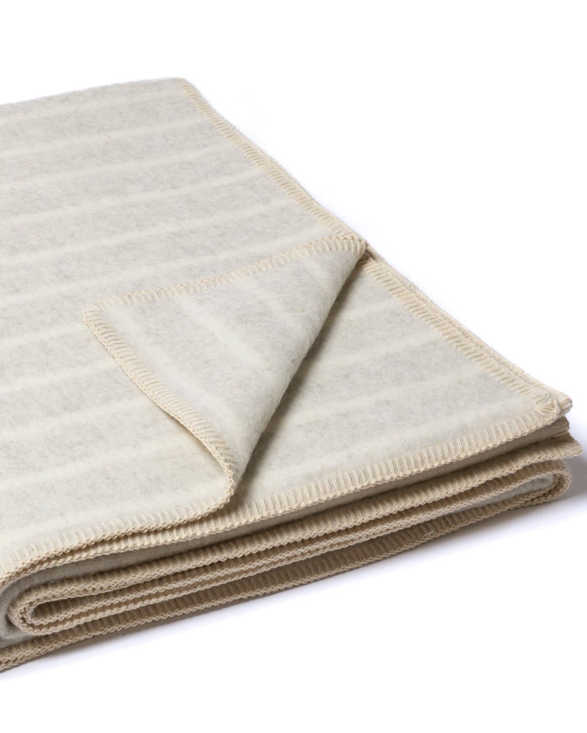 A folded cream-colored knit blanket with thin, horizontal beige stripes, shown on a clean white background.