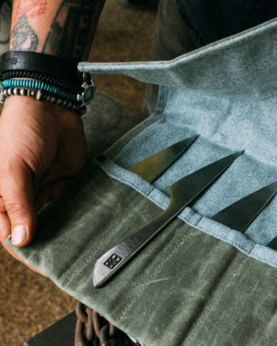 Ryan Fogerty holding a wool case with his Damascus steak knife set inside.