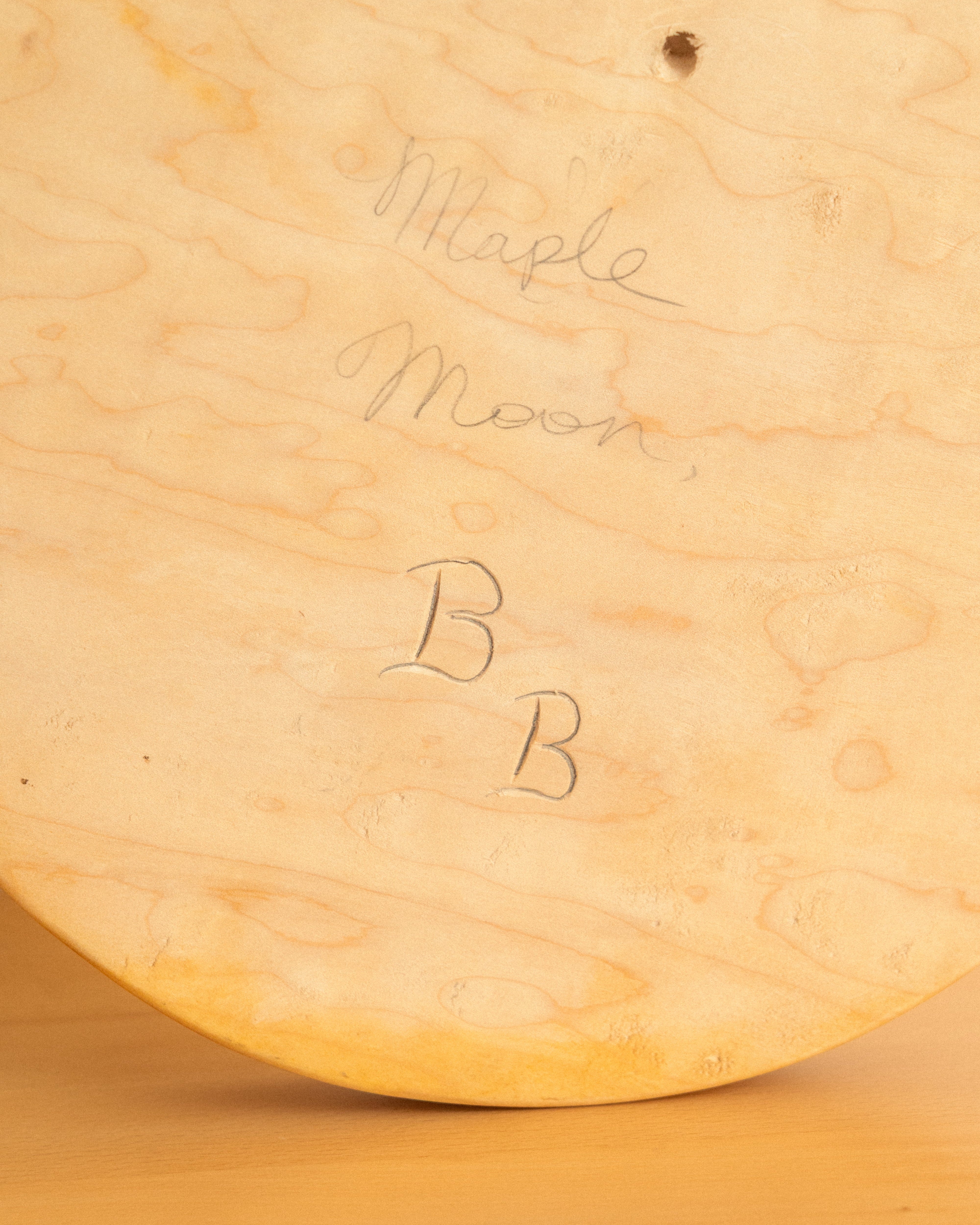 Close-up of a wooden surface with 'Maple Moon' and 'BB' initials.