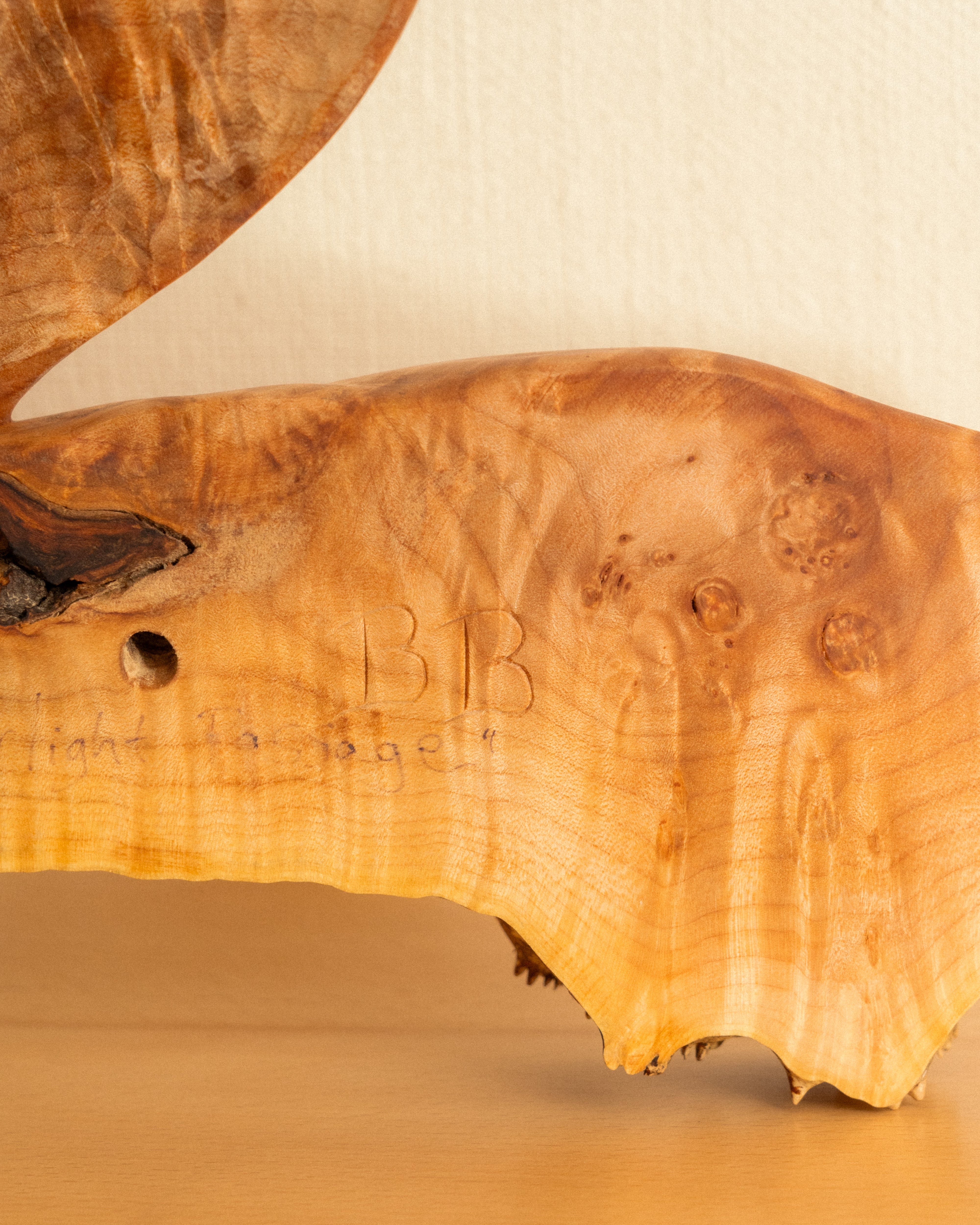 Wooden carving with a textured finish and 'BB' initials.