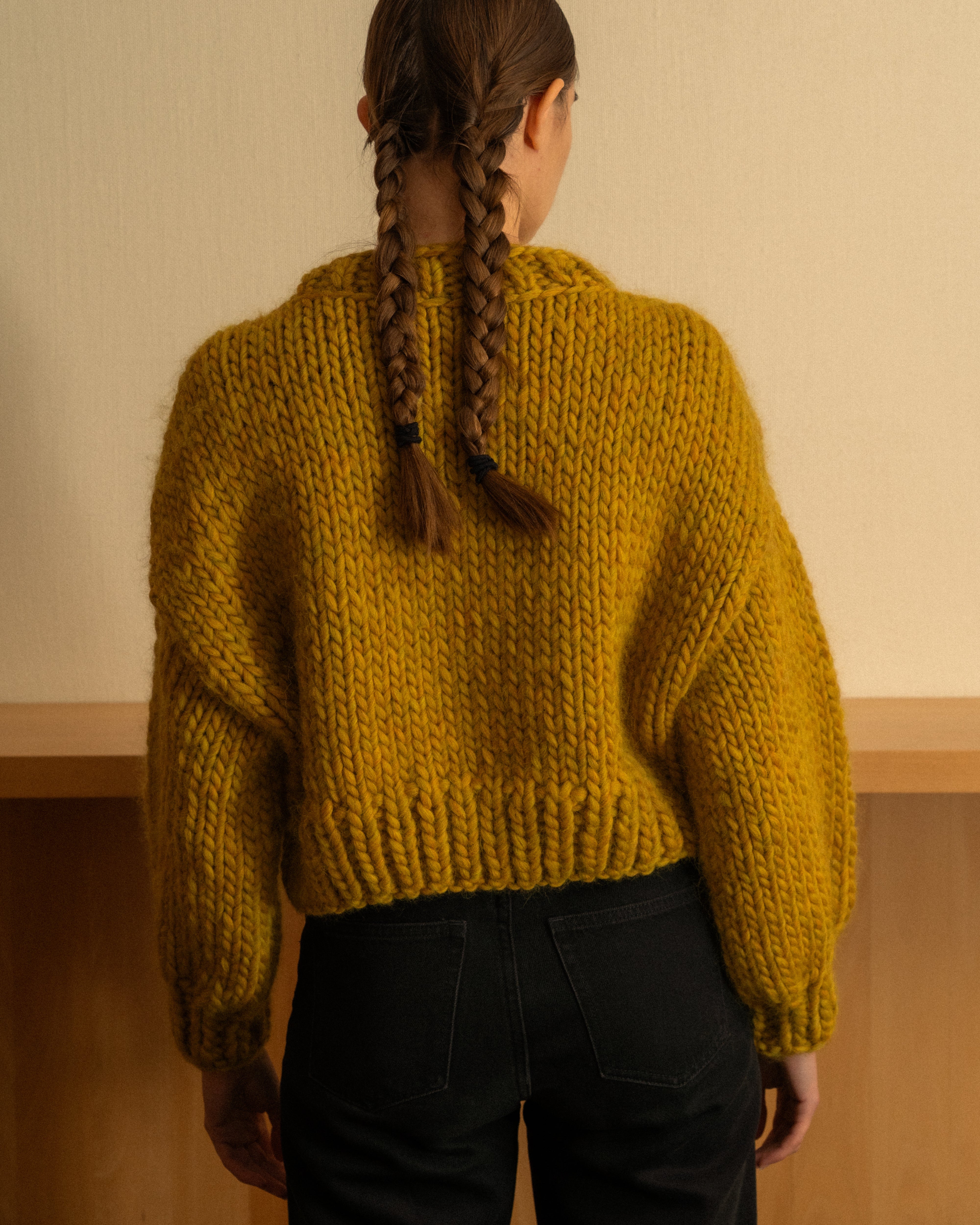 Woman wearing an ochre merino wool knit crewneck by Diane Rudge