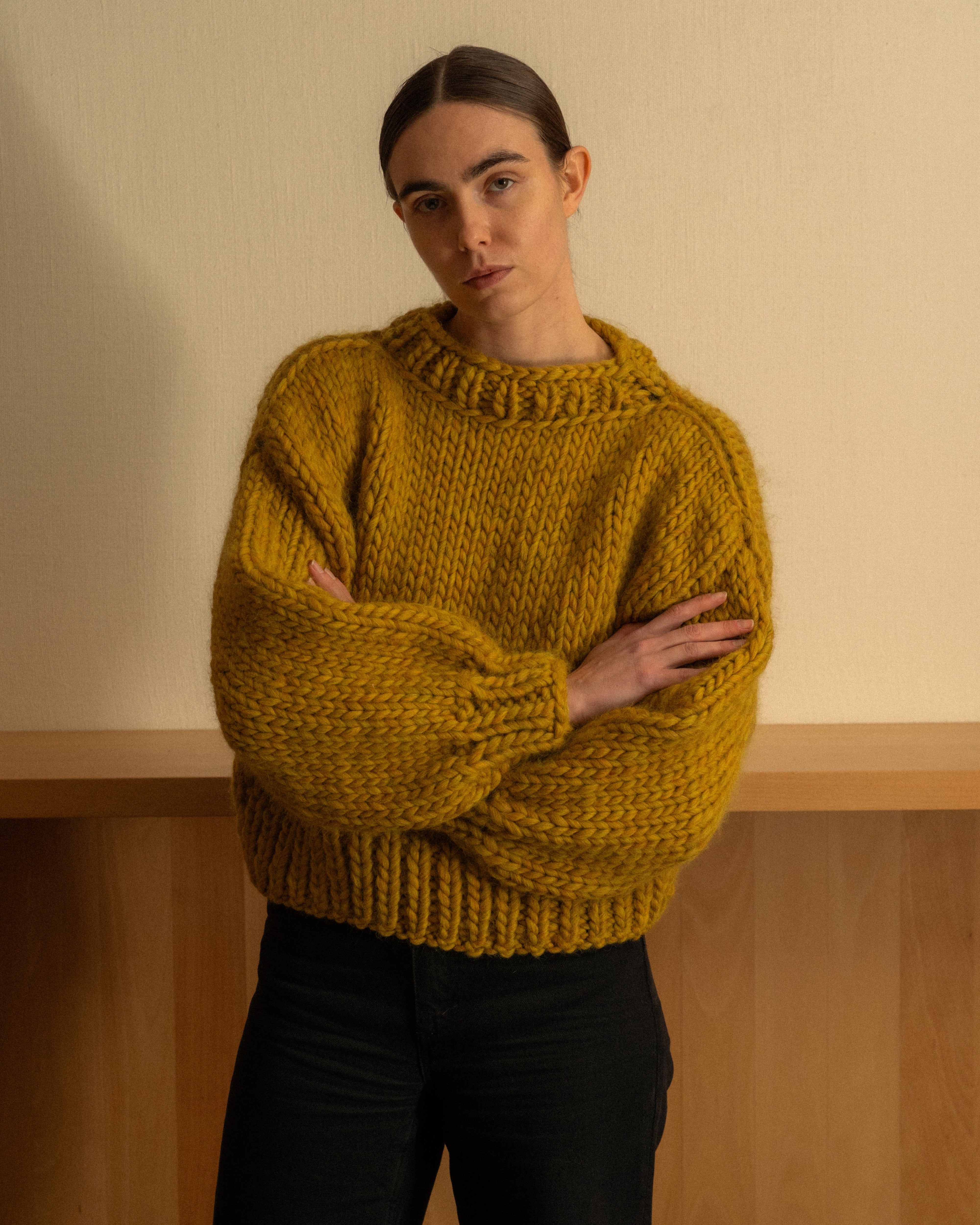 Woman wearing an ochre merino wool knit crewneck by Diane Rudge