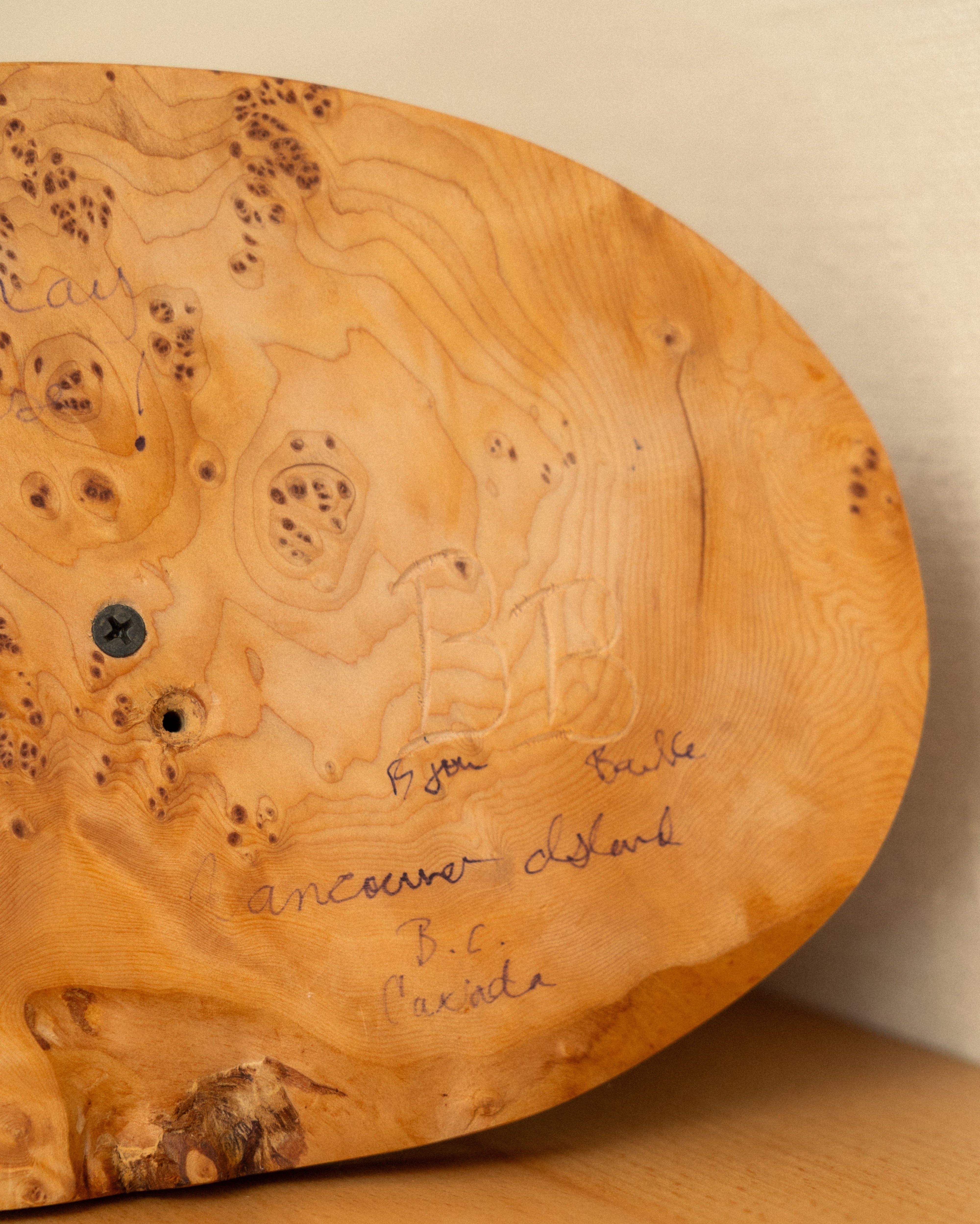 Wooden base of a carving with natural grain and text BB Bjorn Banke Vancouver Island B.C. Canada