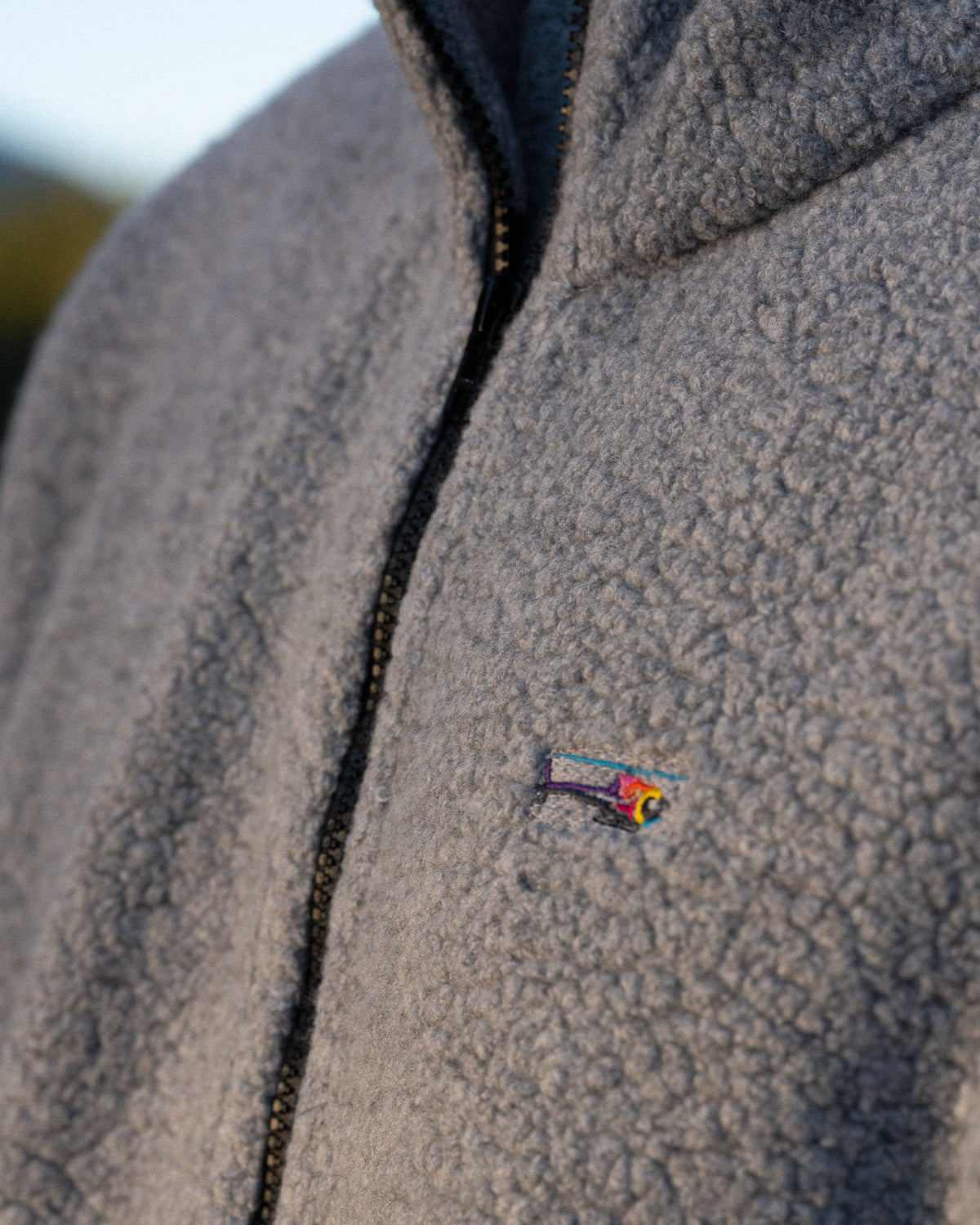 a helicopter logo on a grey fleece jacket