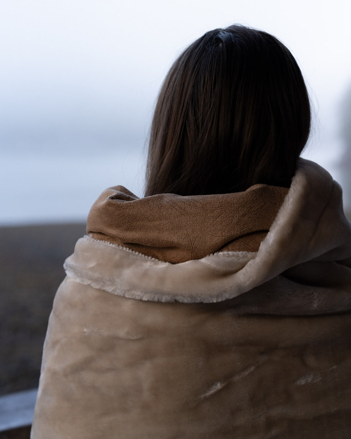 close up of the nimmo bay boat blanket wrapped around a person with a background of fog