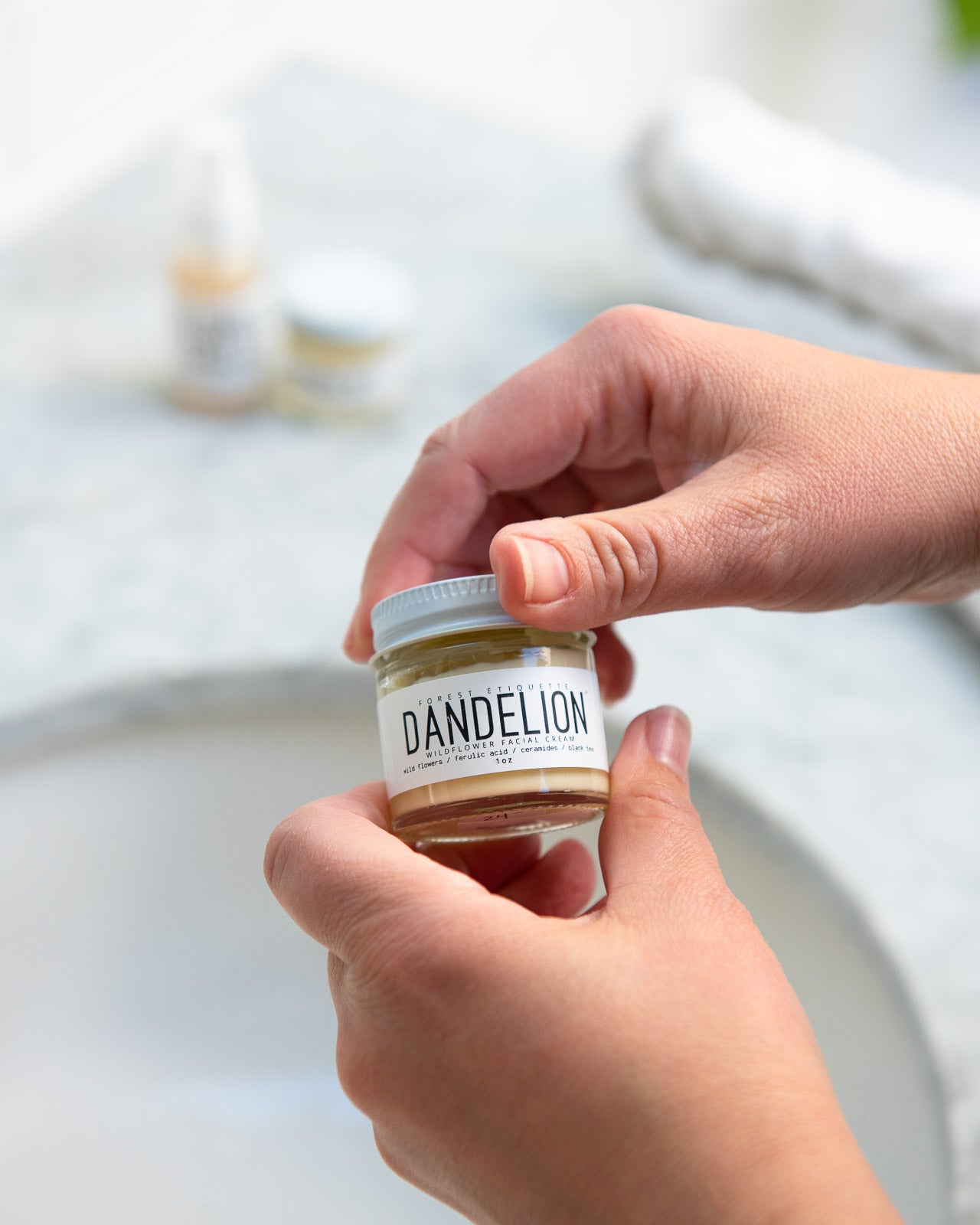 model opening jar of dandelion lotion