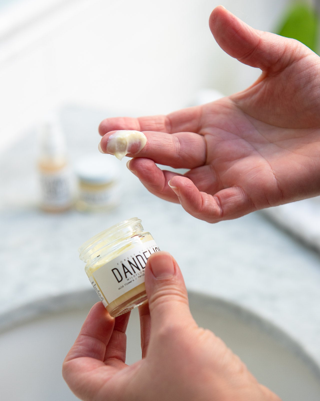 model with dandelion moisturizer on her finger