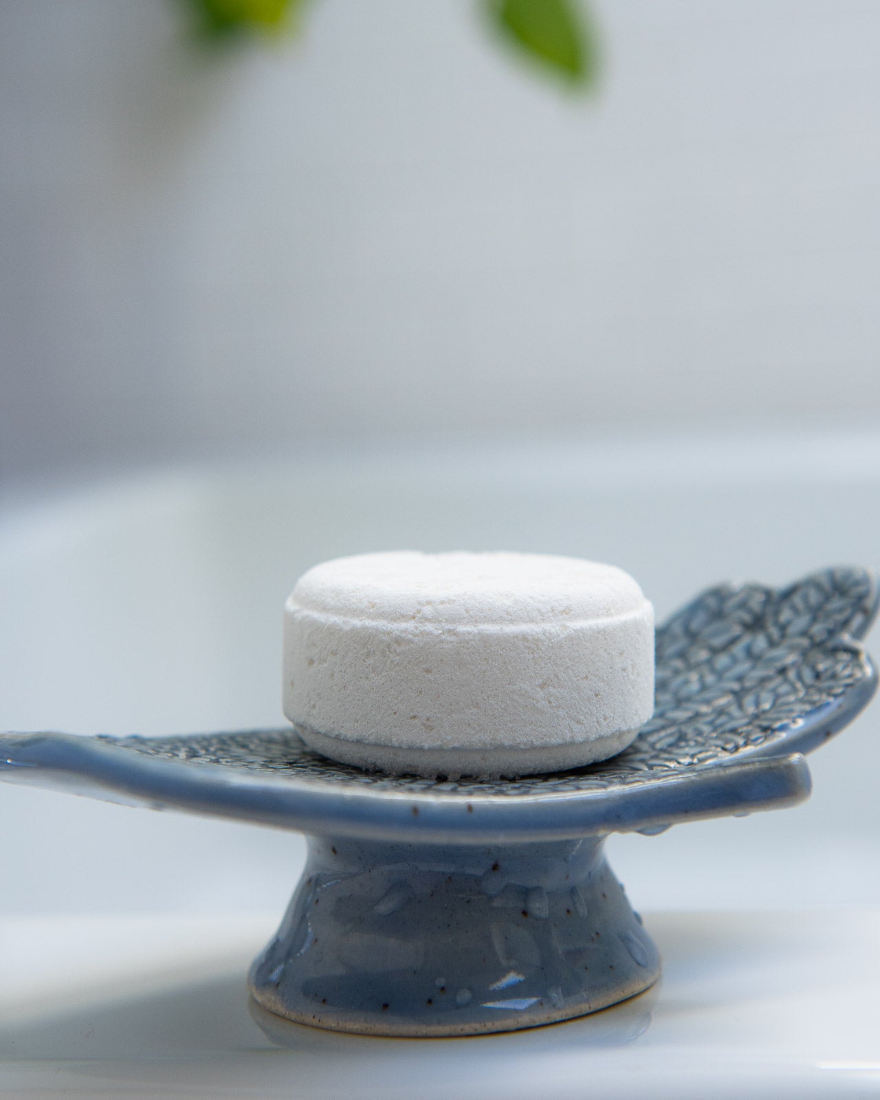 soap dish with fresh bath bomb on it. profile shot.