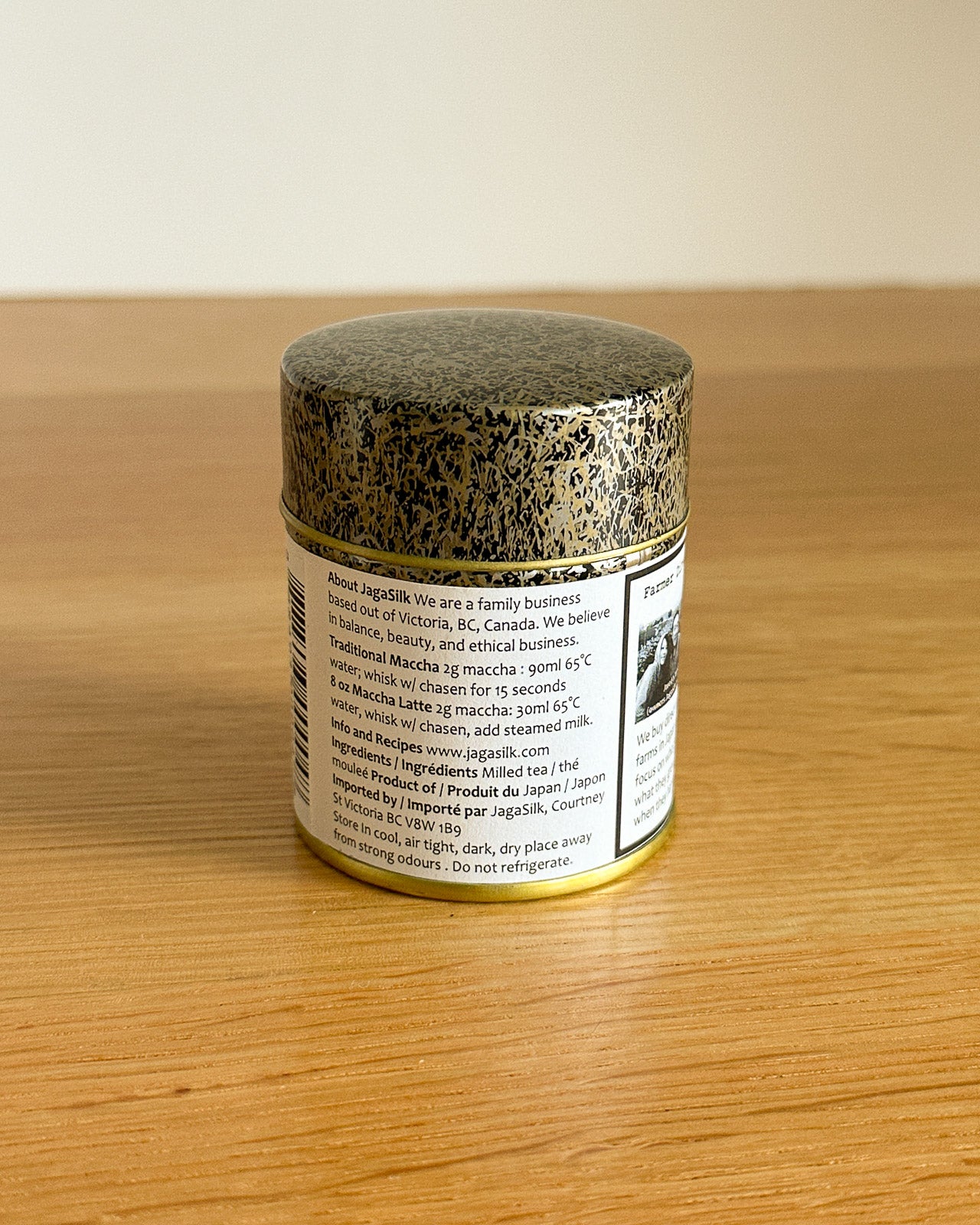 Matcha jar with a gold lid on a wooden surface