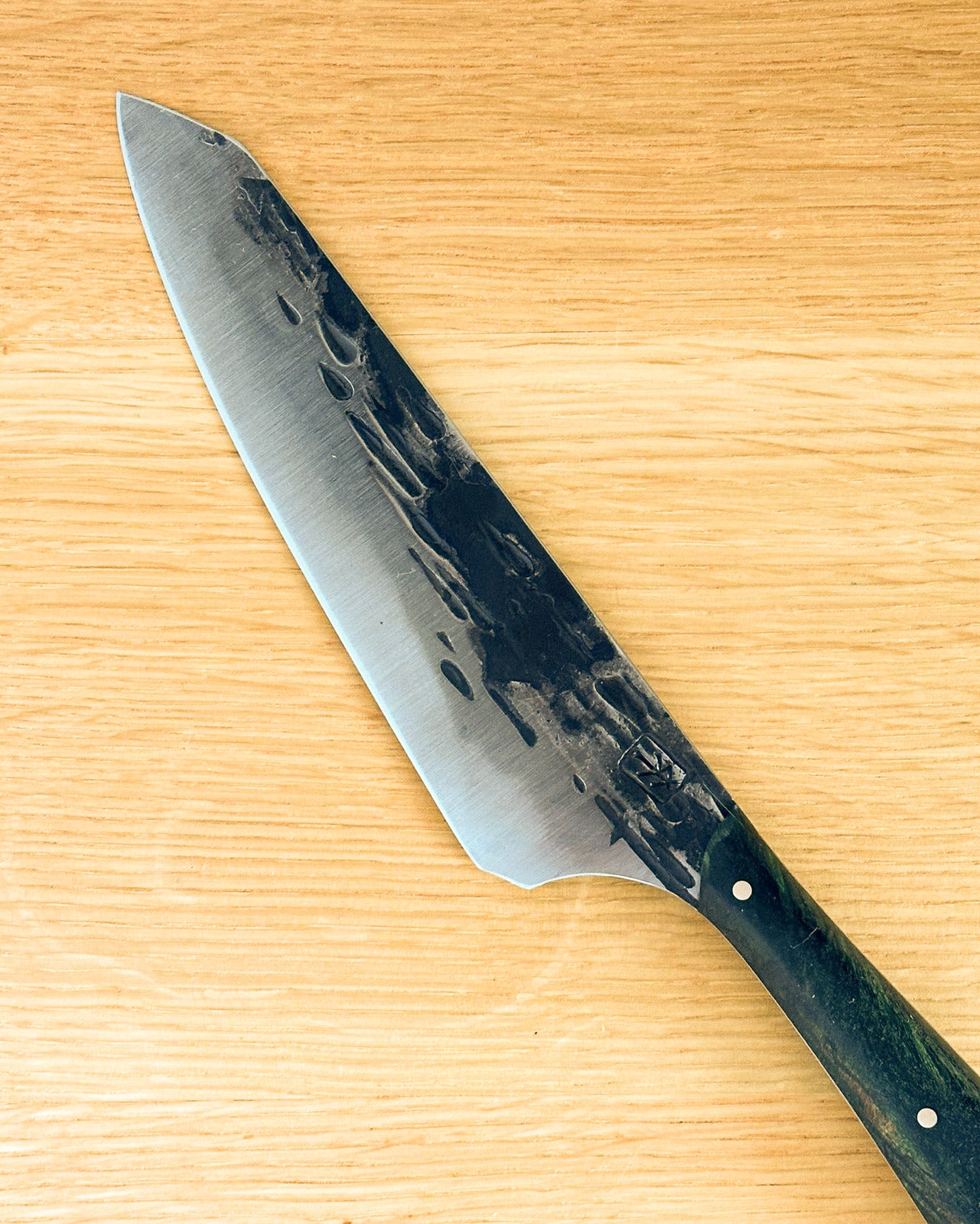 Knife with a green handle on a wooden surface