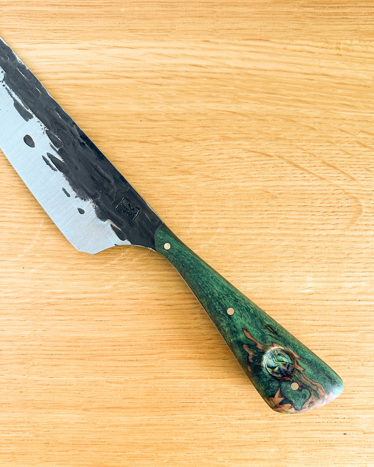 Knife with a green handle on a wooden surface