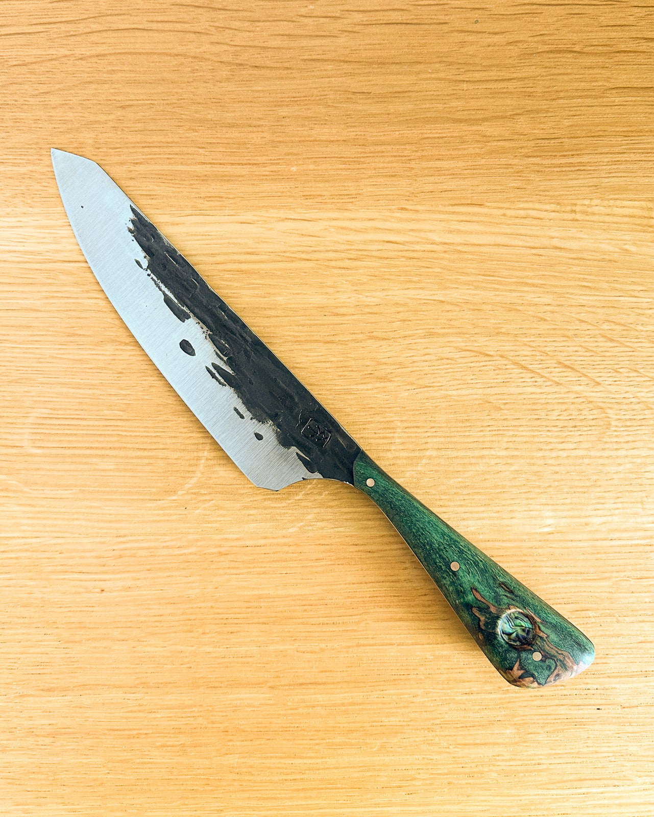 Knife with a green handle on a wooden surface