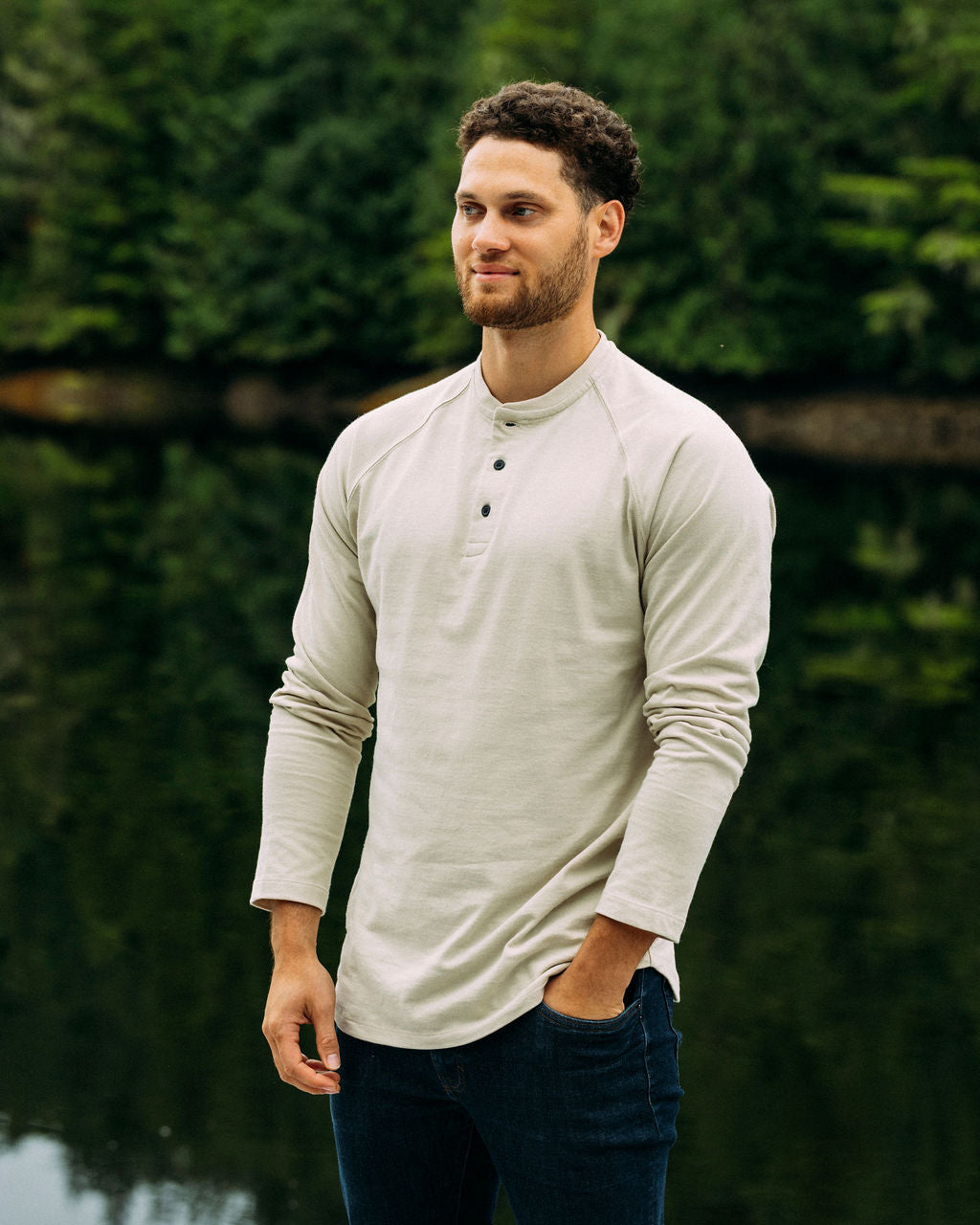 Man wearing a pelican anian henley standing in a forest.