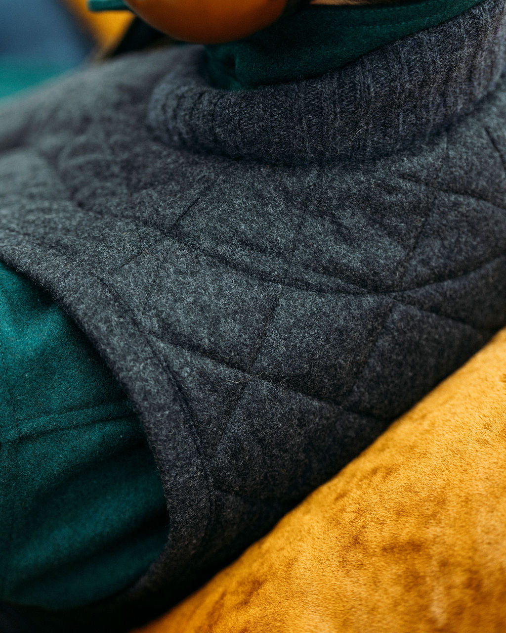 Close-up of a textured fabric with gray, green, and yellow colors.