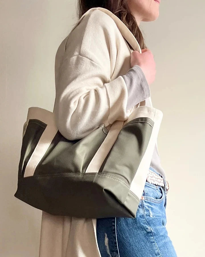 Person holding a green and Rather green amiga petite tote bag against a plain background