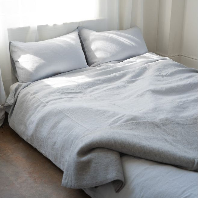 Gray bedding set on a bed with white pillows