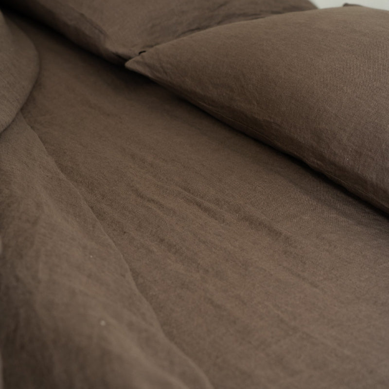 Brown textured fabric with a pillow on a neutral background