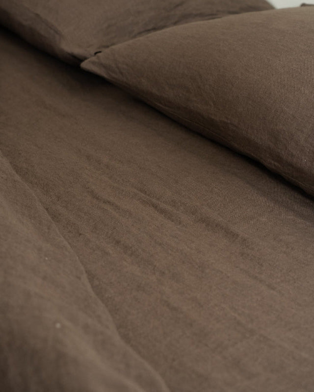 Brown textured fabric with a pillow on a neutral background