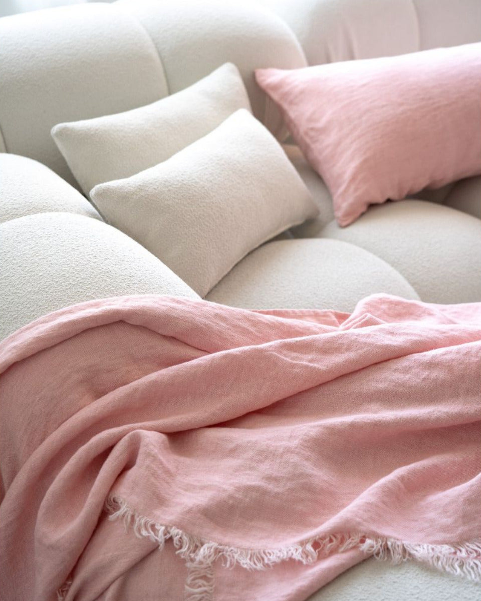 Pink blanket and pillows on a white sofa