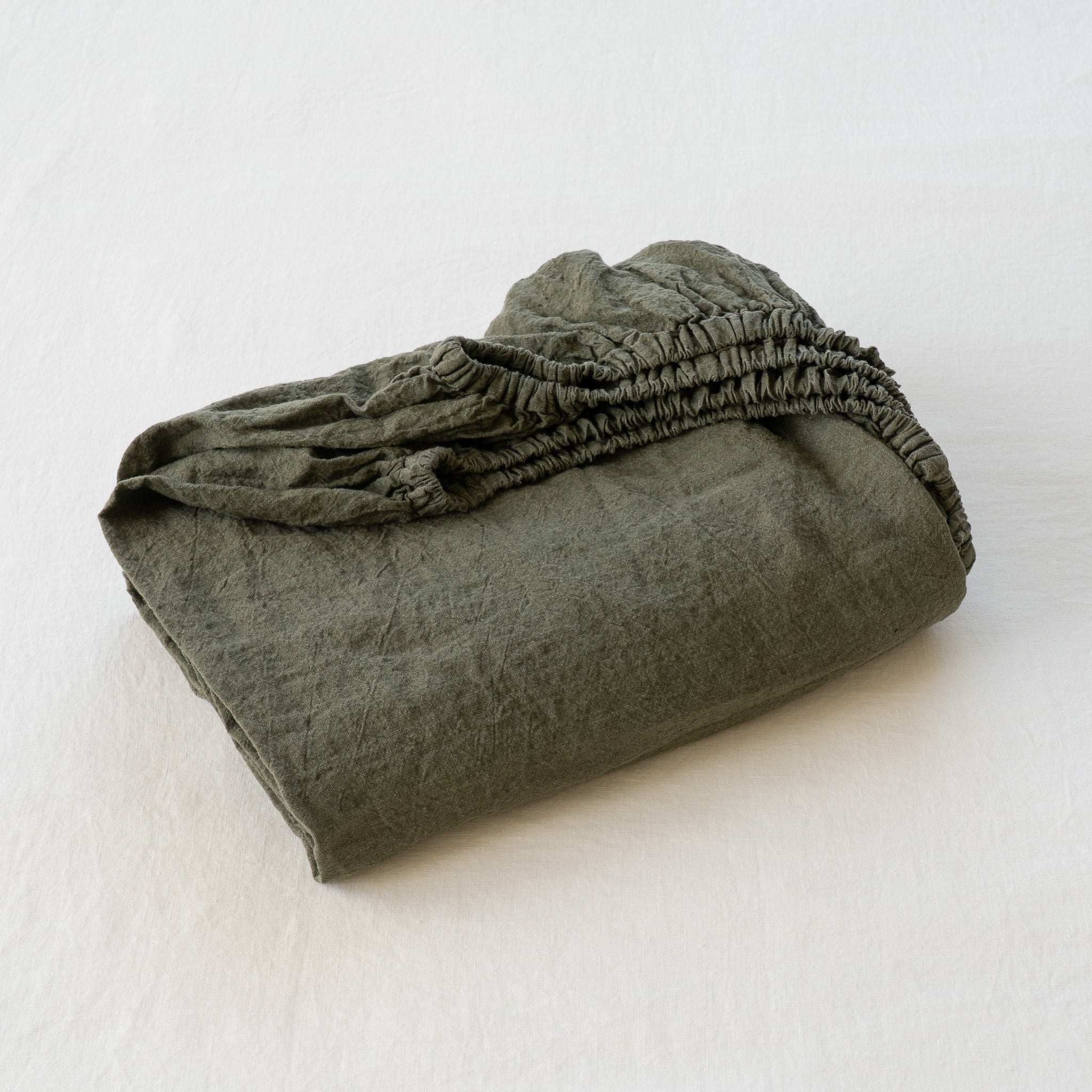 Folded green fabric on a white background