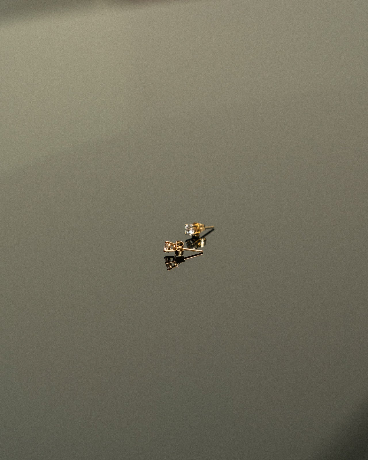 Gold earring on a dark gray background