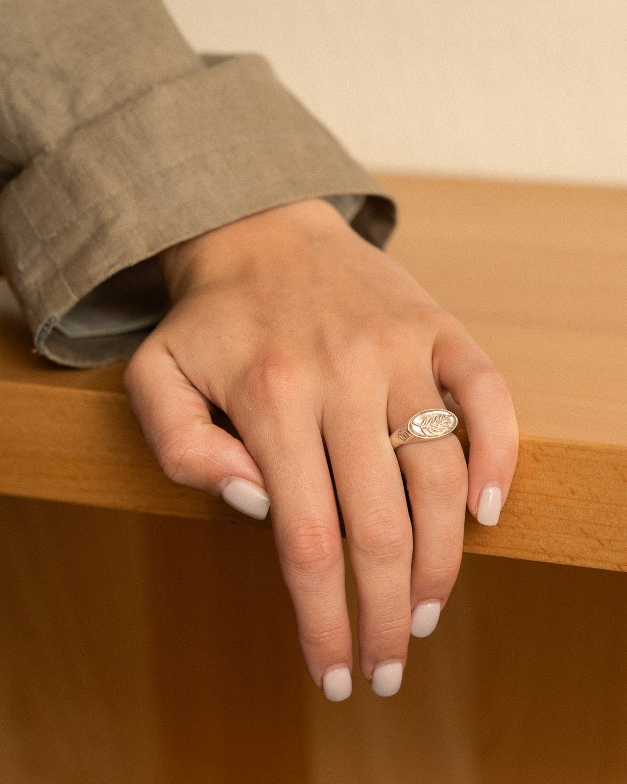 Hand with a ring on a wooden surface