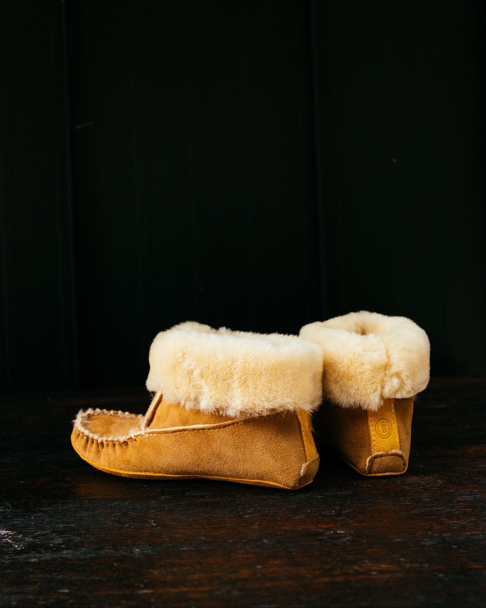 Pair of yellow suede boots with white fur lining on a dark background