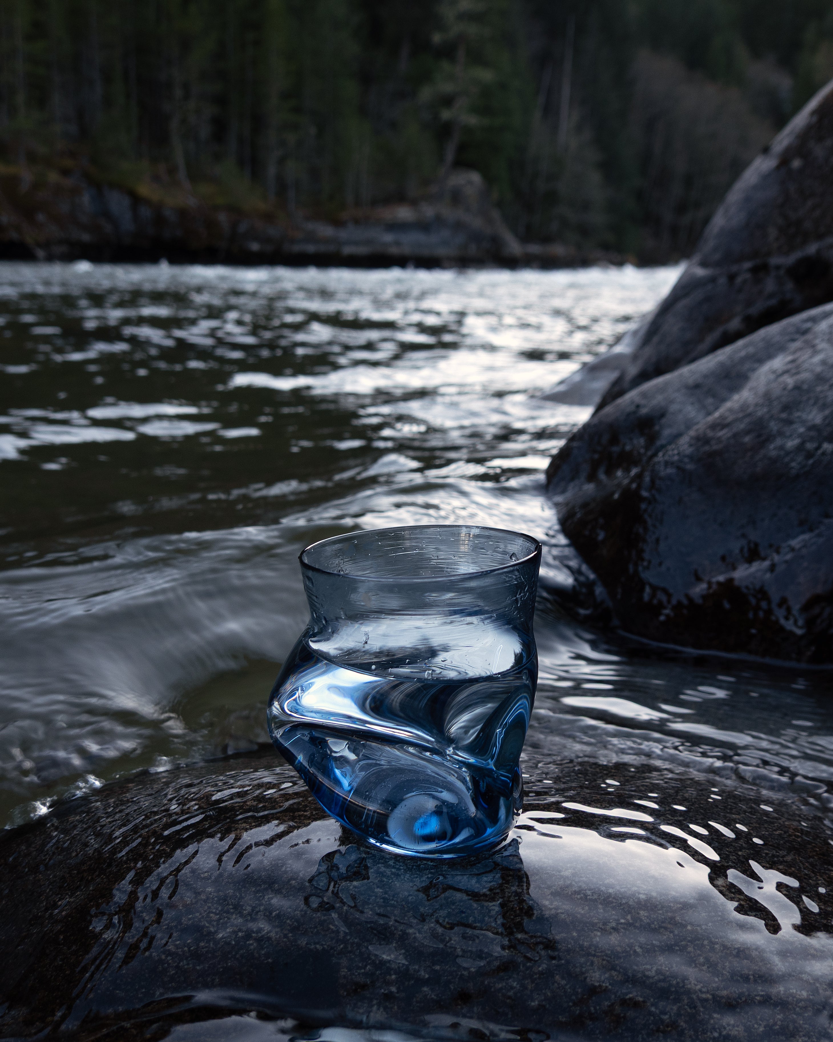 Goodbeast Crushed Cup in blue on a rock with water in the background