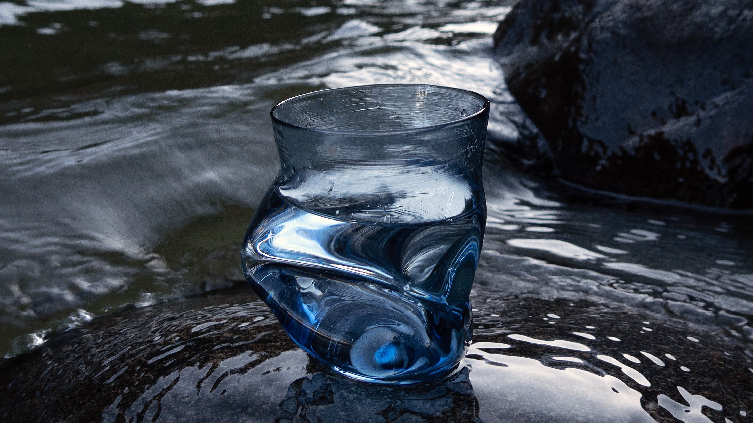 Goodbeast Crushed Cup in blue on a rock with water in the background