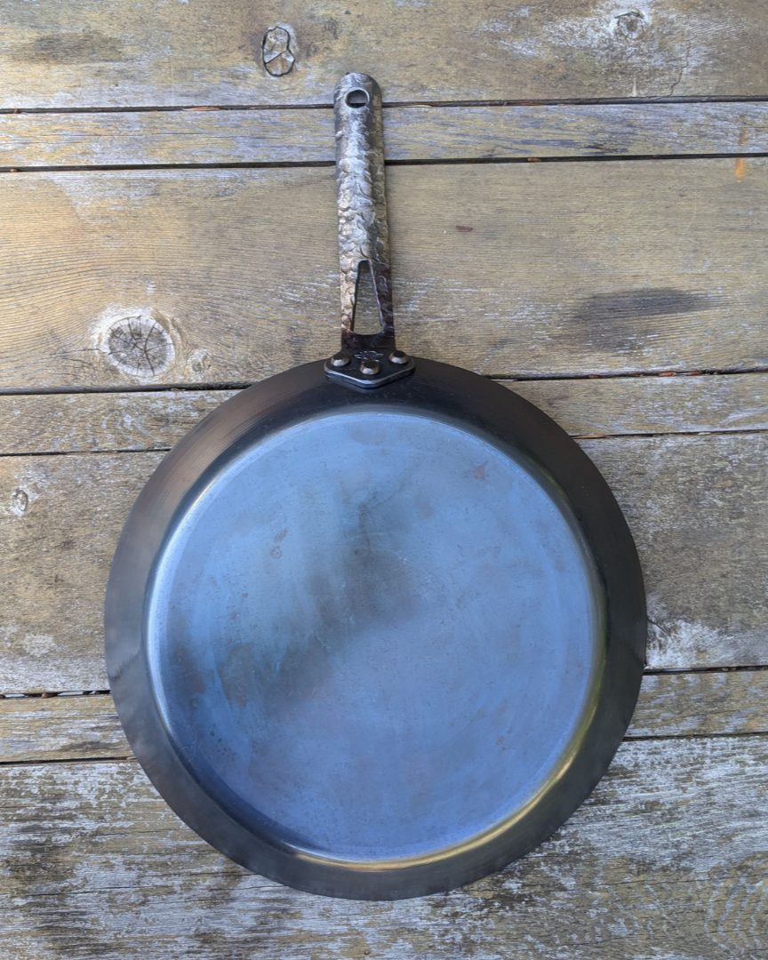 leechtown blacksmith pan lying on a wooden table. bottom viw