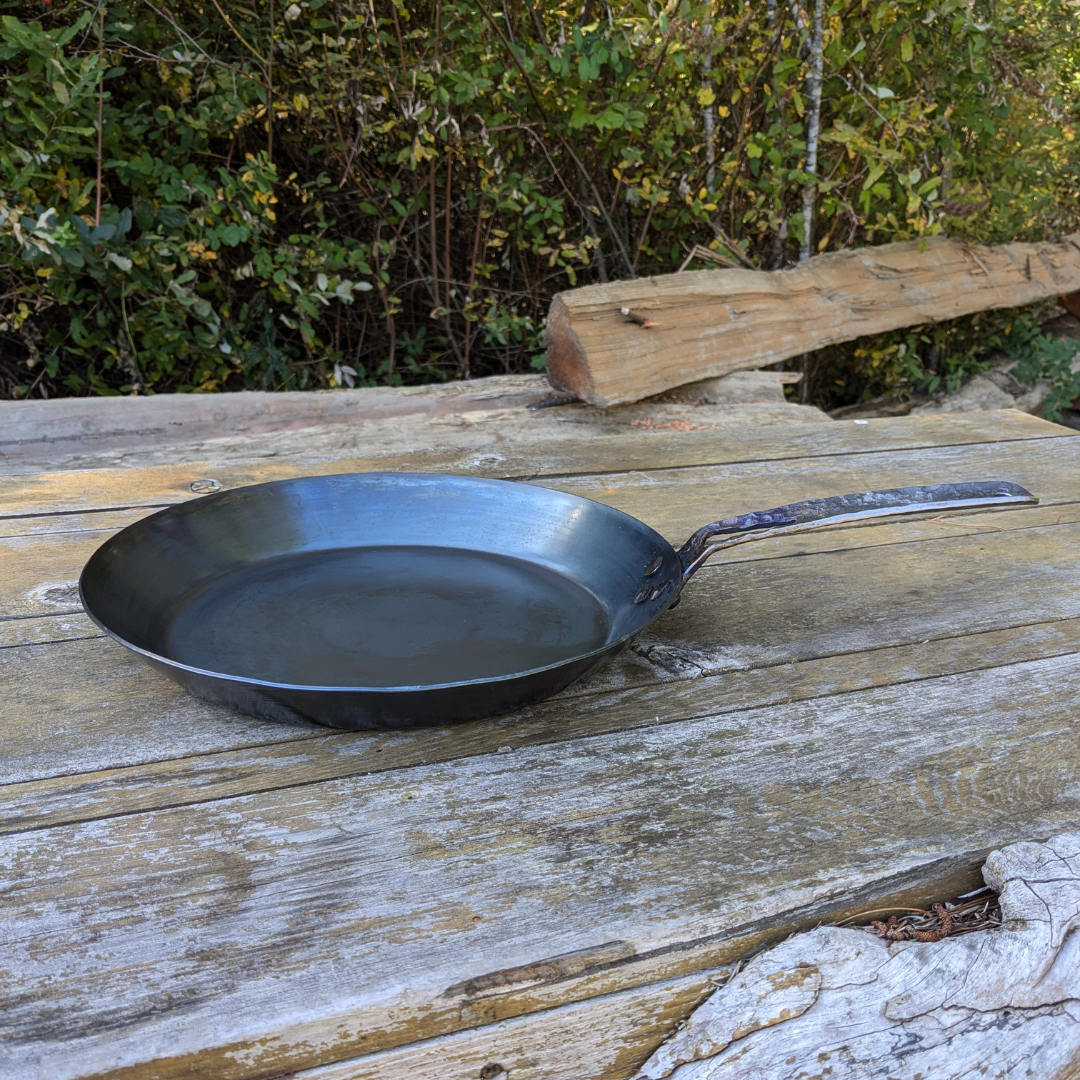 leechtown blacksmith pan lying on a wooden table. side view
