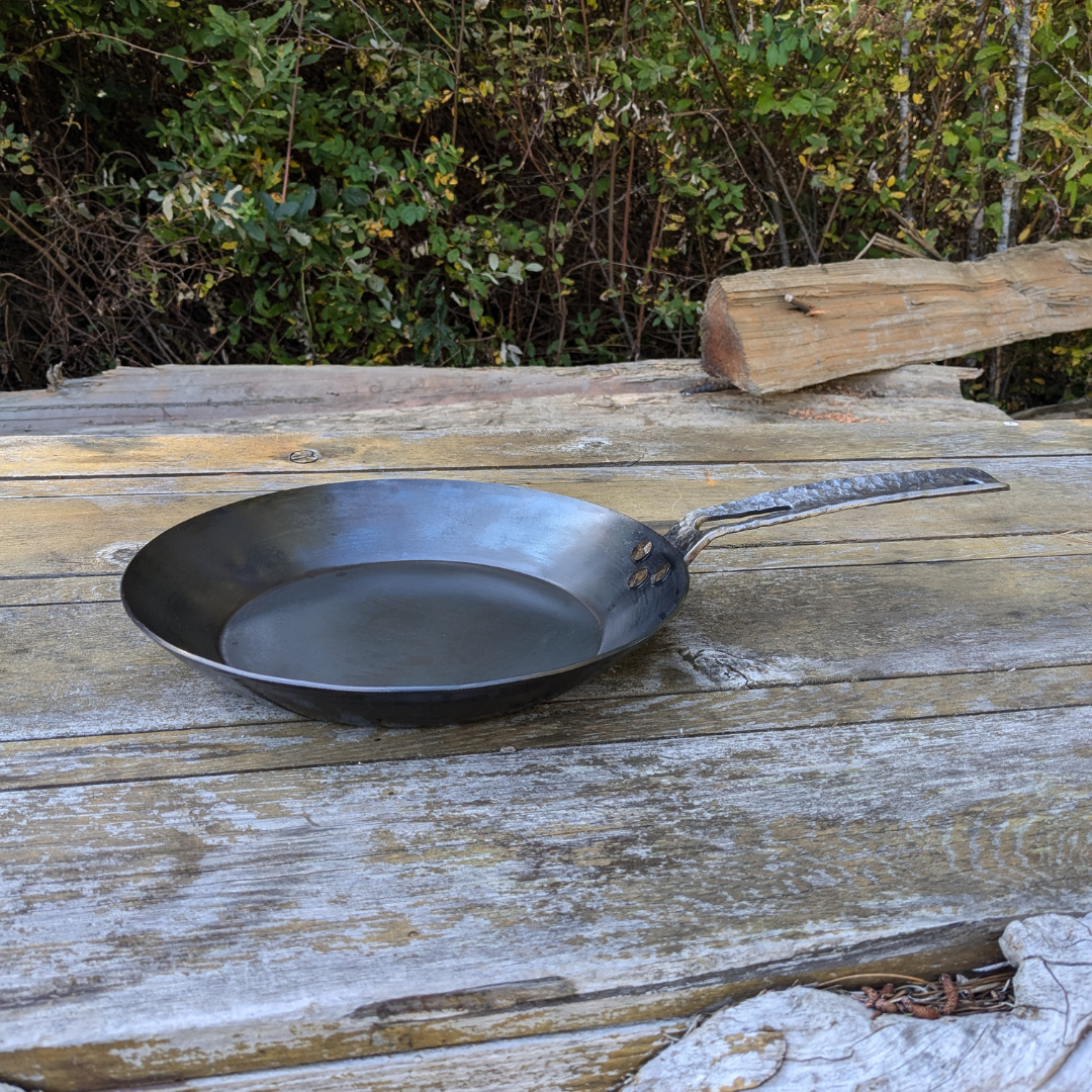 leechtown blacksmith pan lying on a wooden table. side view