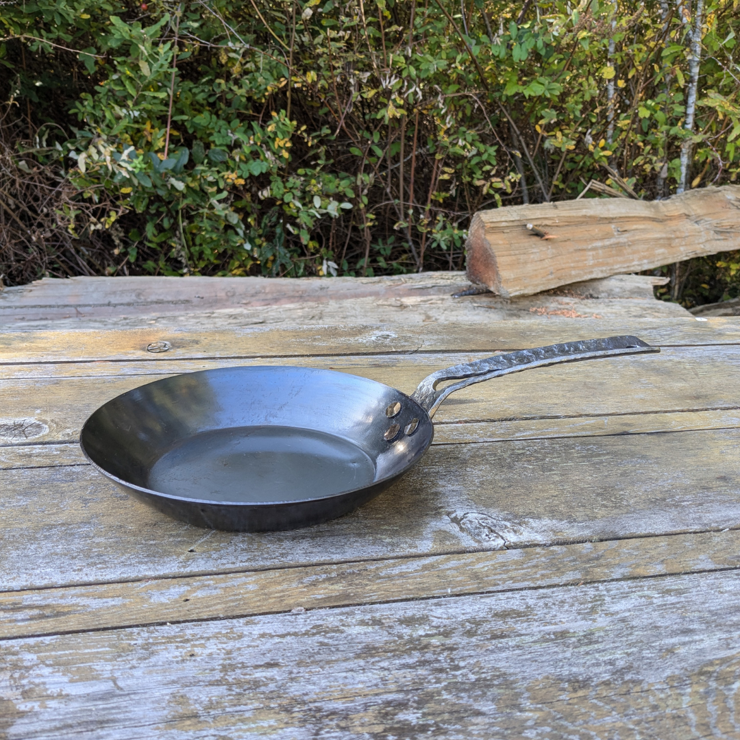 leechtown blacksmith pan lying on a wooden table. side view