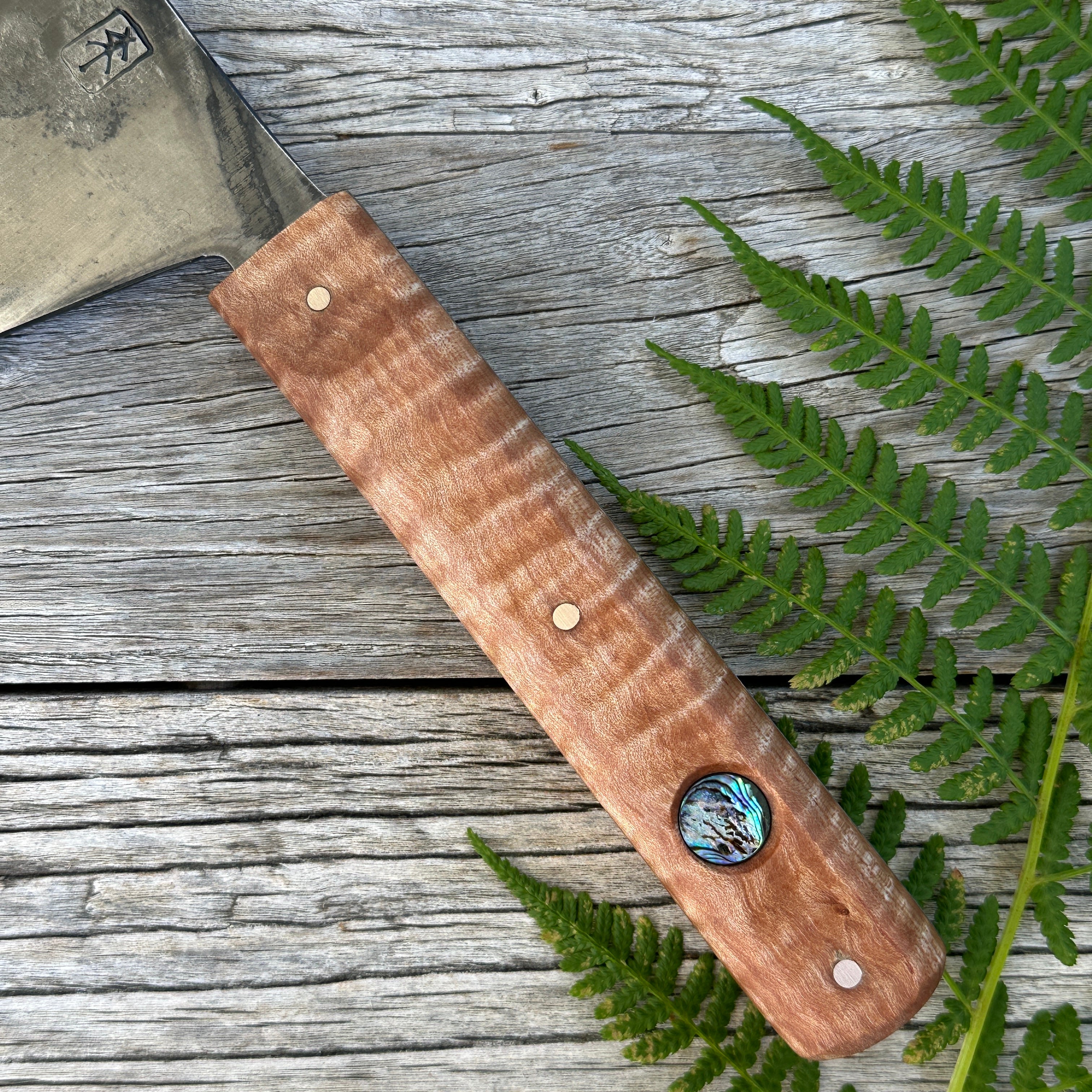 Leechtown Blacksmith Co. for Confluence Nimmo Bay knife with a wooden handle on a wooden surface with fern leaves