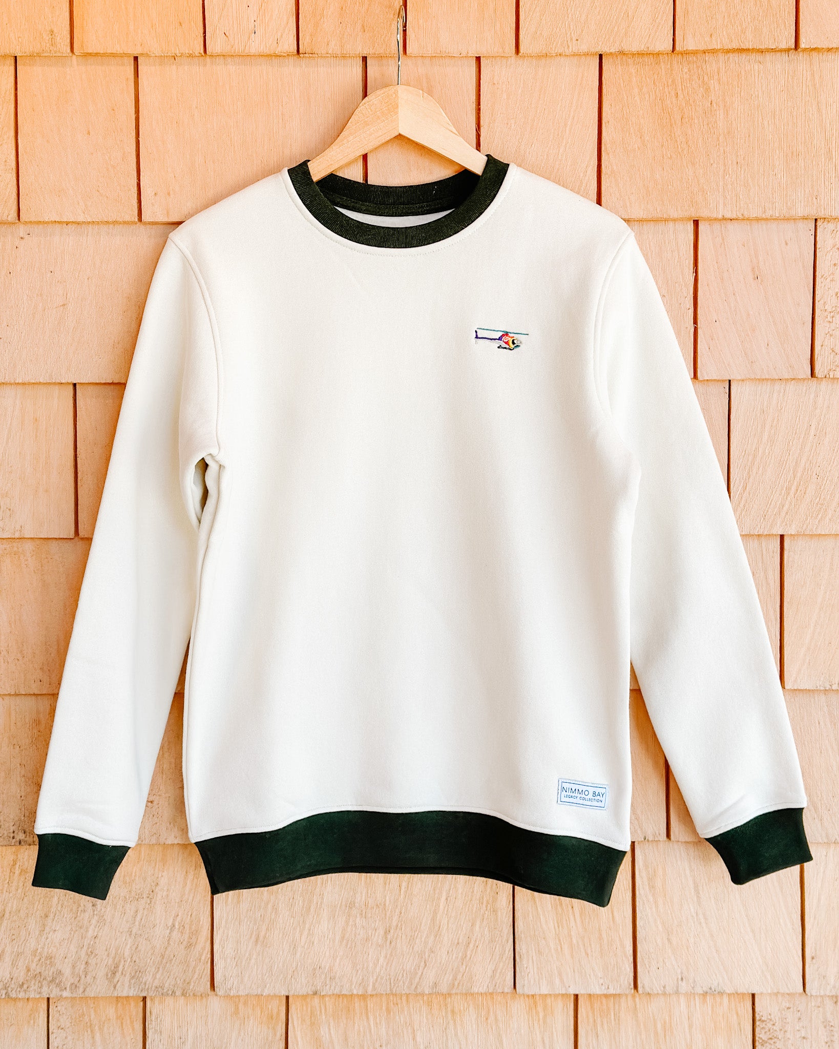the legacy crewneck sweater from anian on a cedar wall