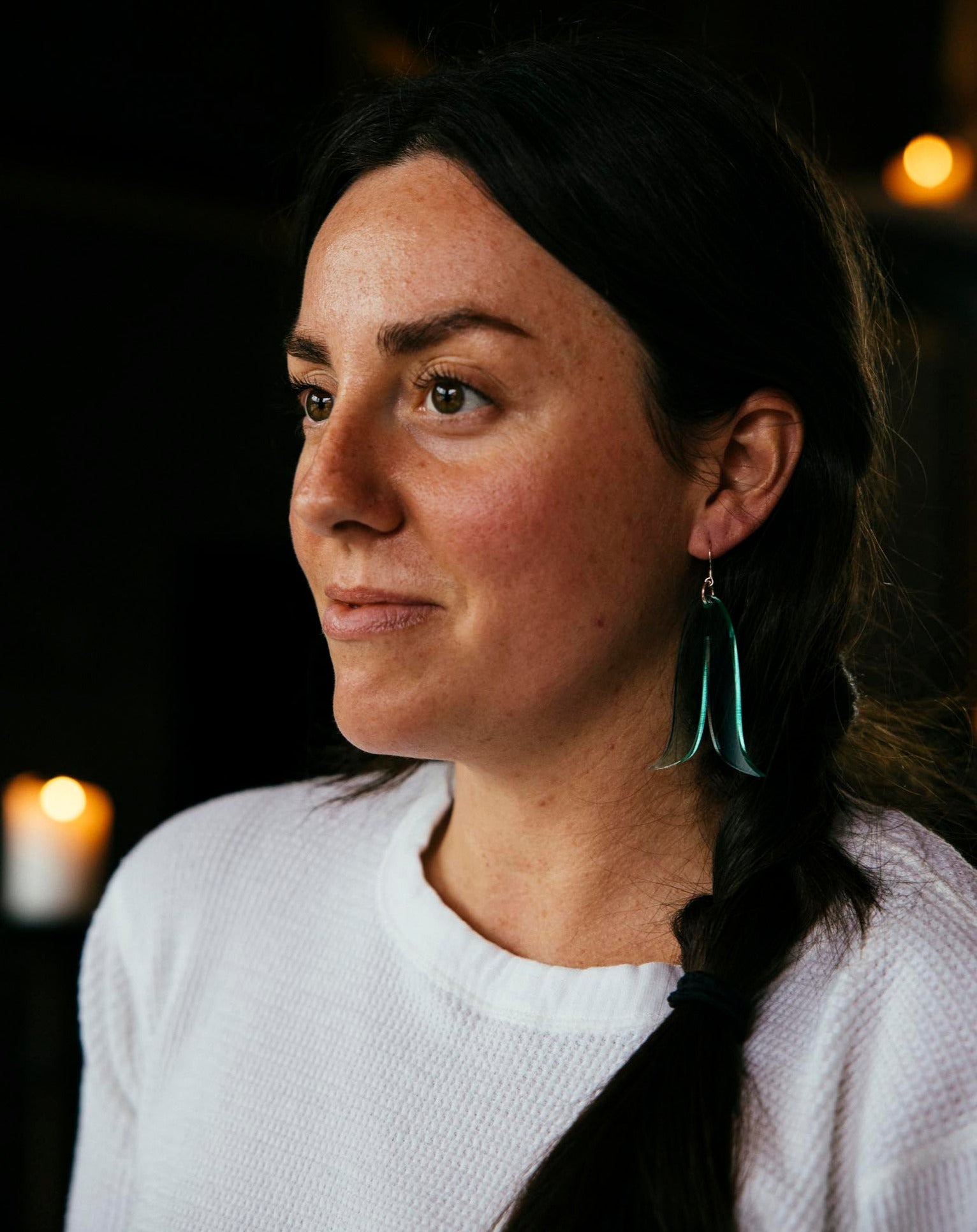 Woman wearing Warren Steven Scotte earrings - joined feather in coke bottle blue