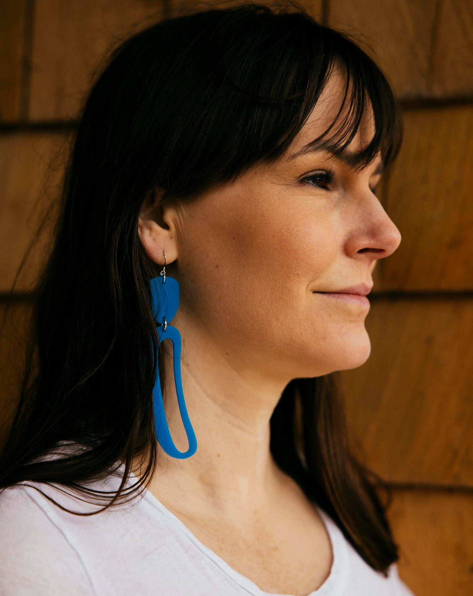 Elongated Ovoid Earrings in Blue by Warren Steven Scott worn by a brunette woman