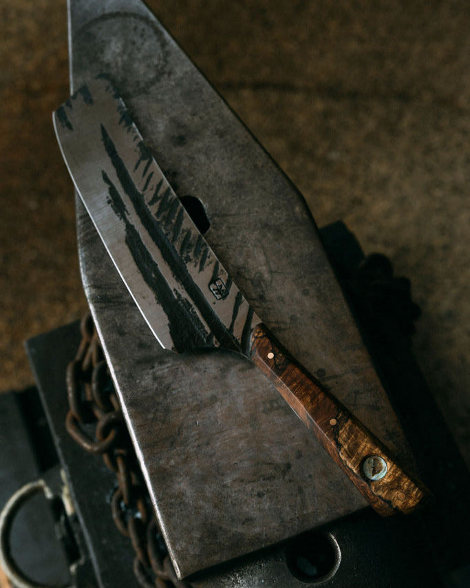 Close up of a Leechtown Blacksmith Co knife on top of an anvil