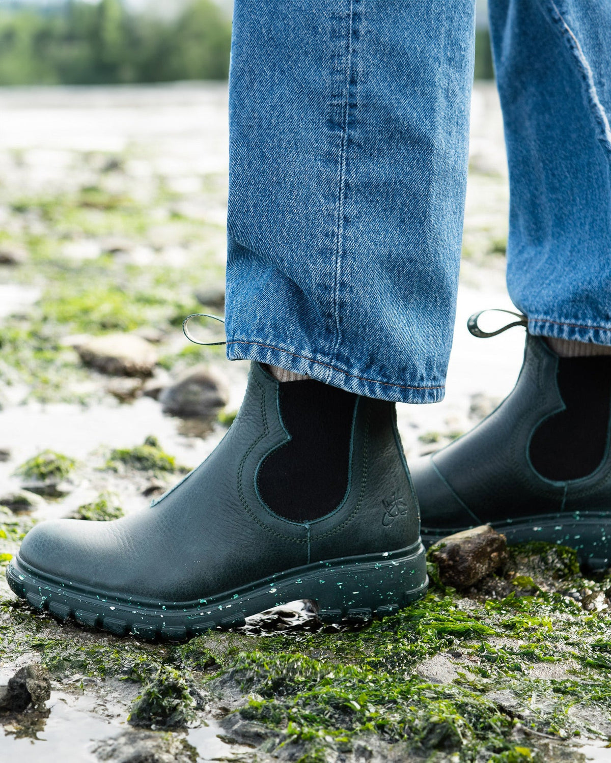 a women wearing green boots on a beach