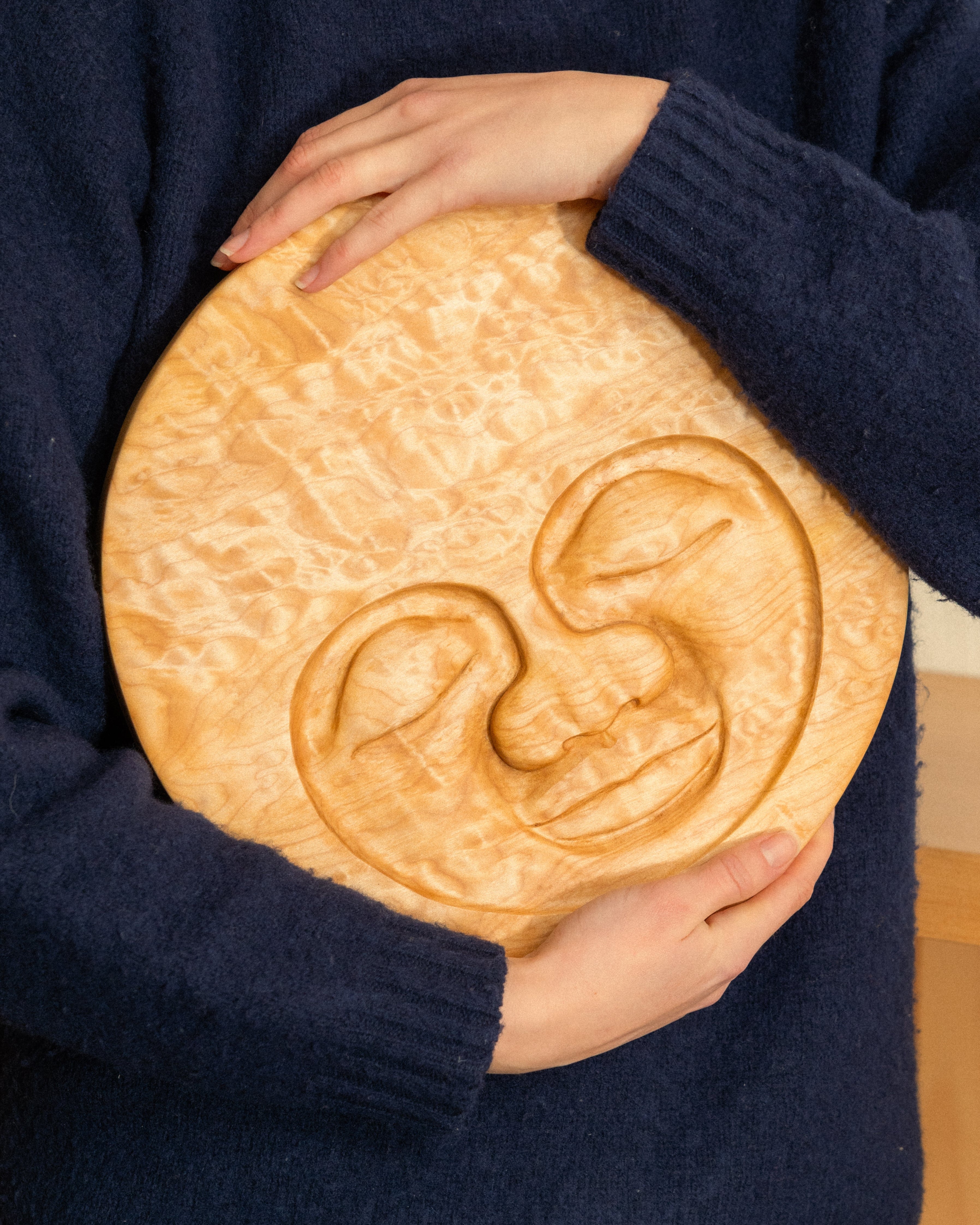 Person holding a Maple Moon face carving