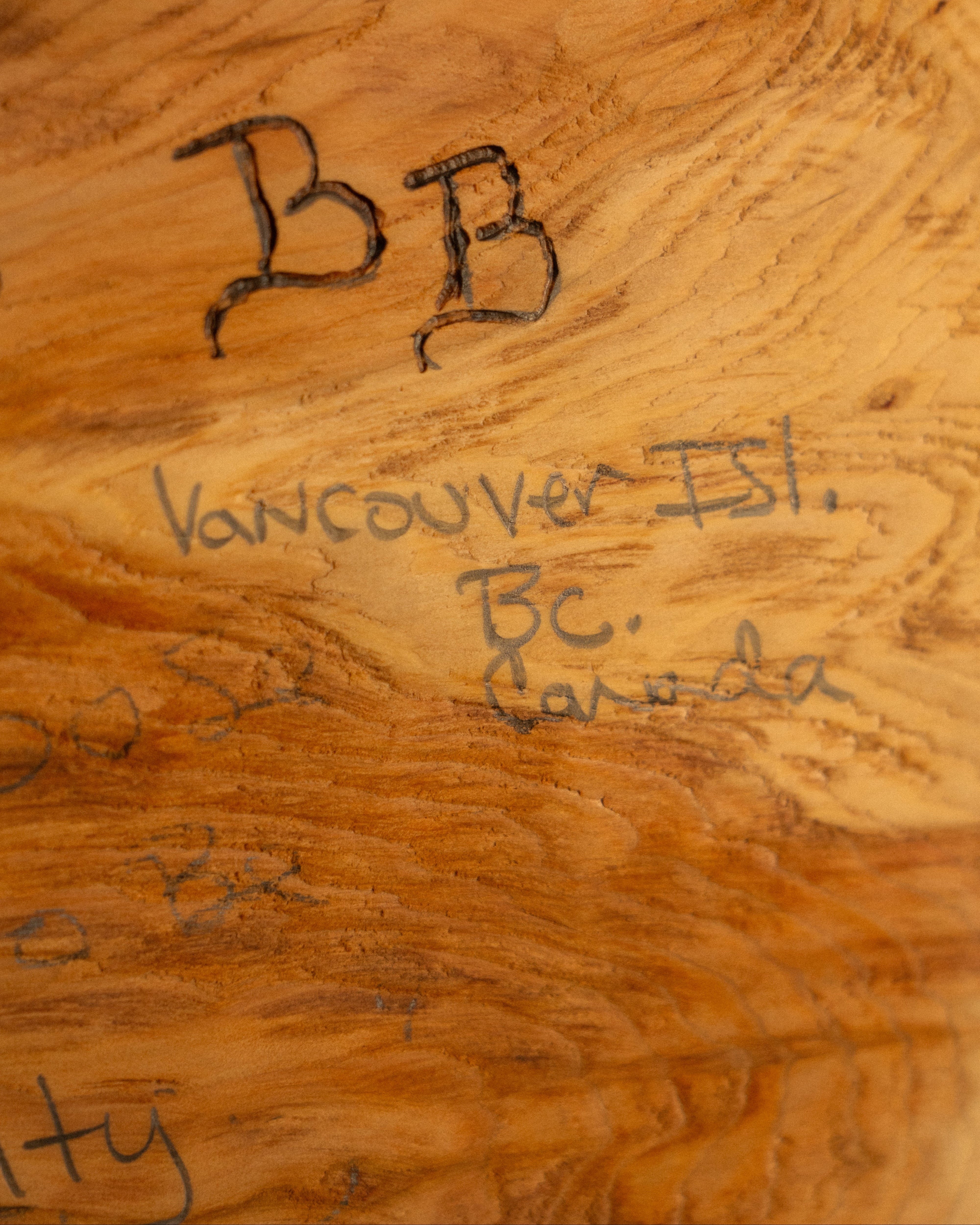 Wooden surface with 'BB' and 'Vancouver Isl. BC Canada' engraved on it