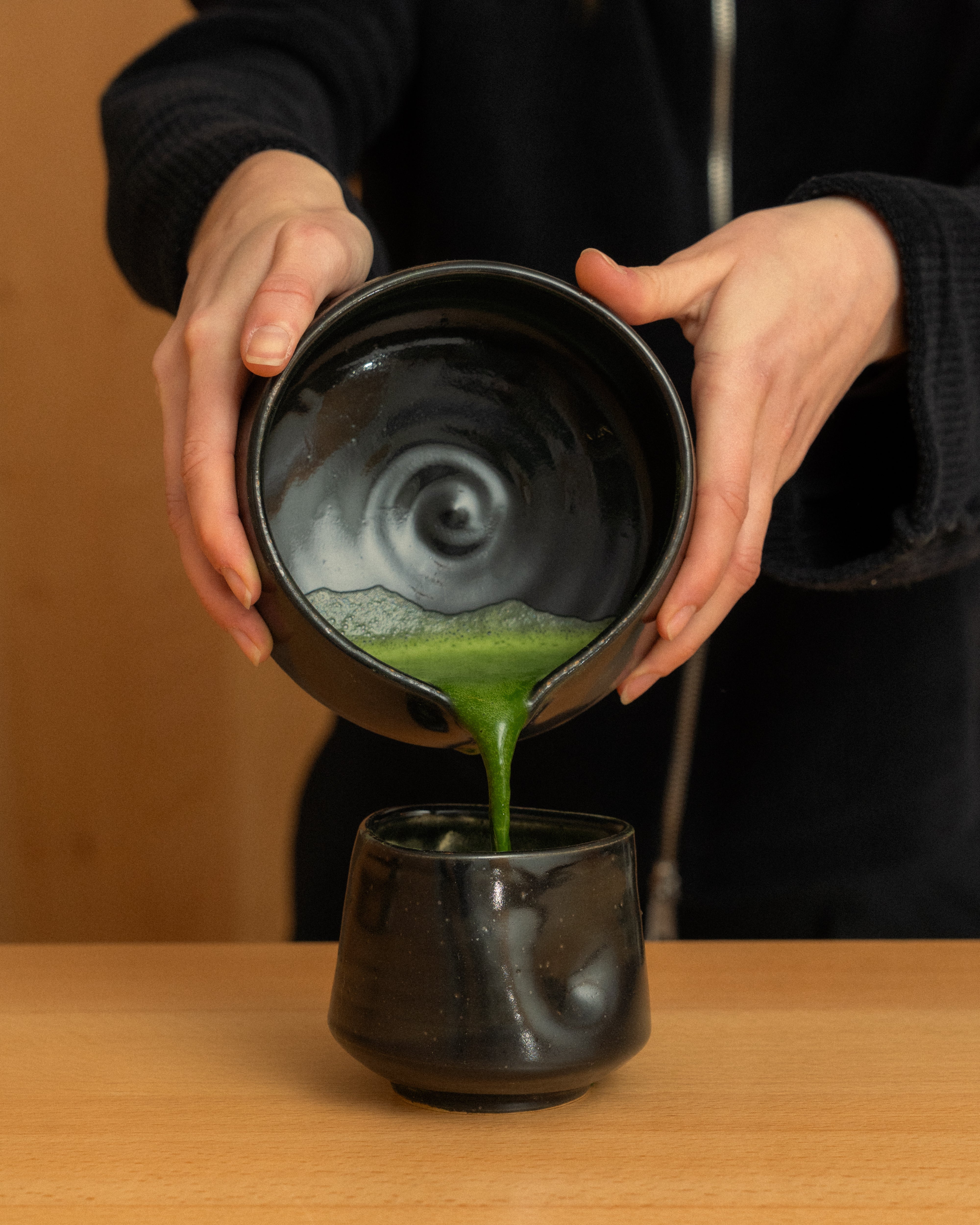A woman pouring maccha into a bowl