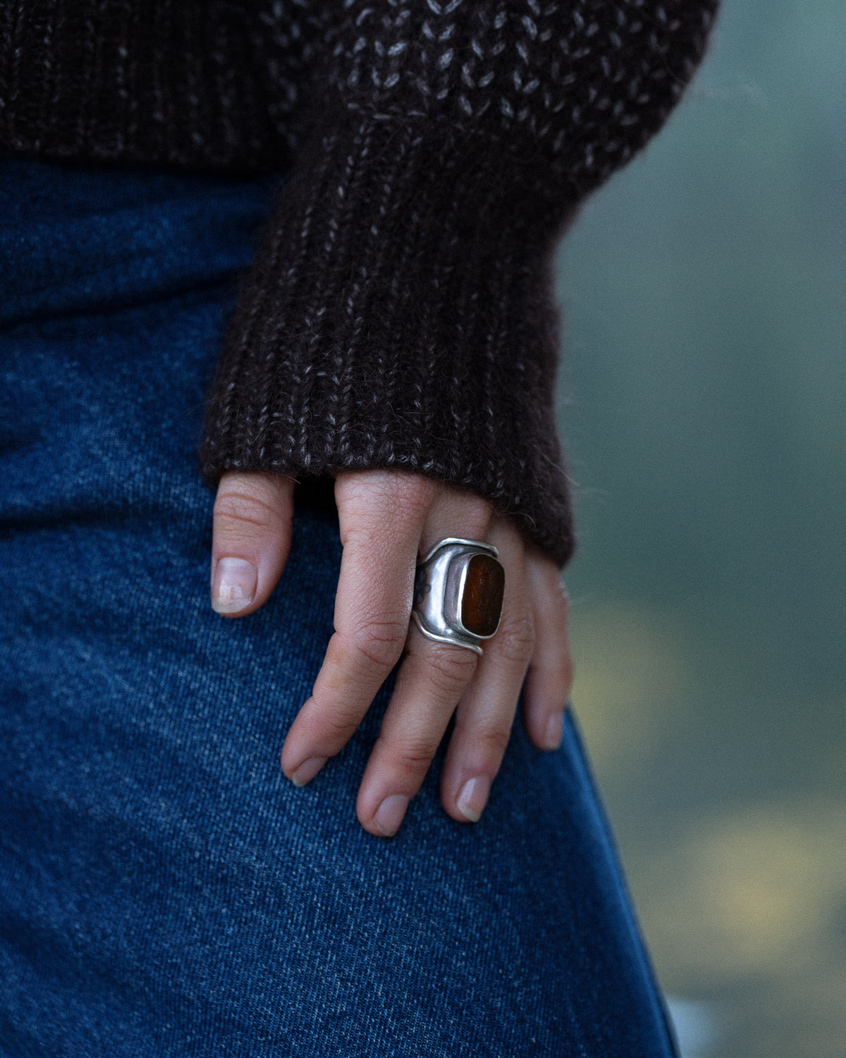 Woman wearing a Bare Knitwear carob brown quarter zip sweater - cuff closeup