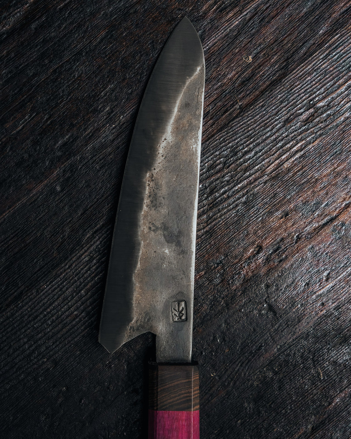close up on knife blade on dark surface