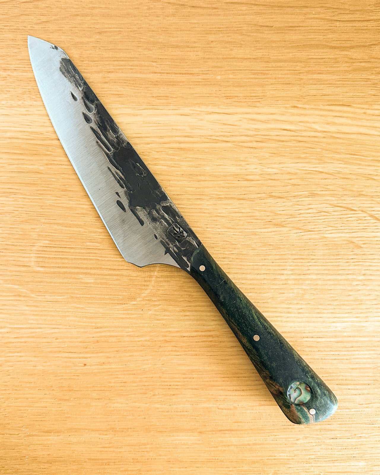 Knife with a green handle on a wooden surface