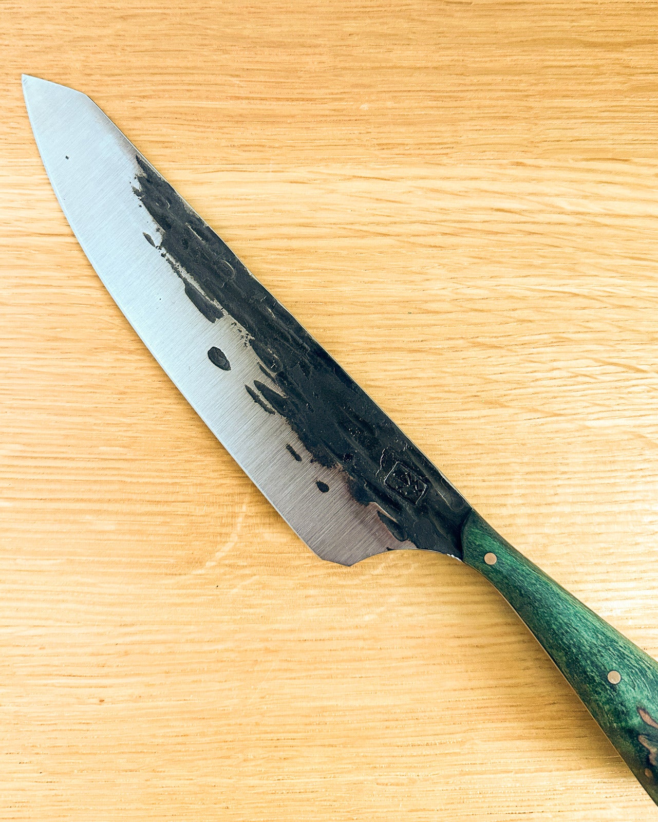 Knife with a green handle on a wooden surface
