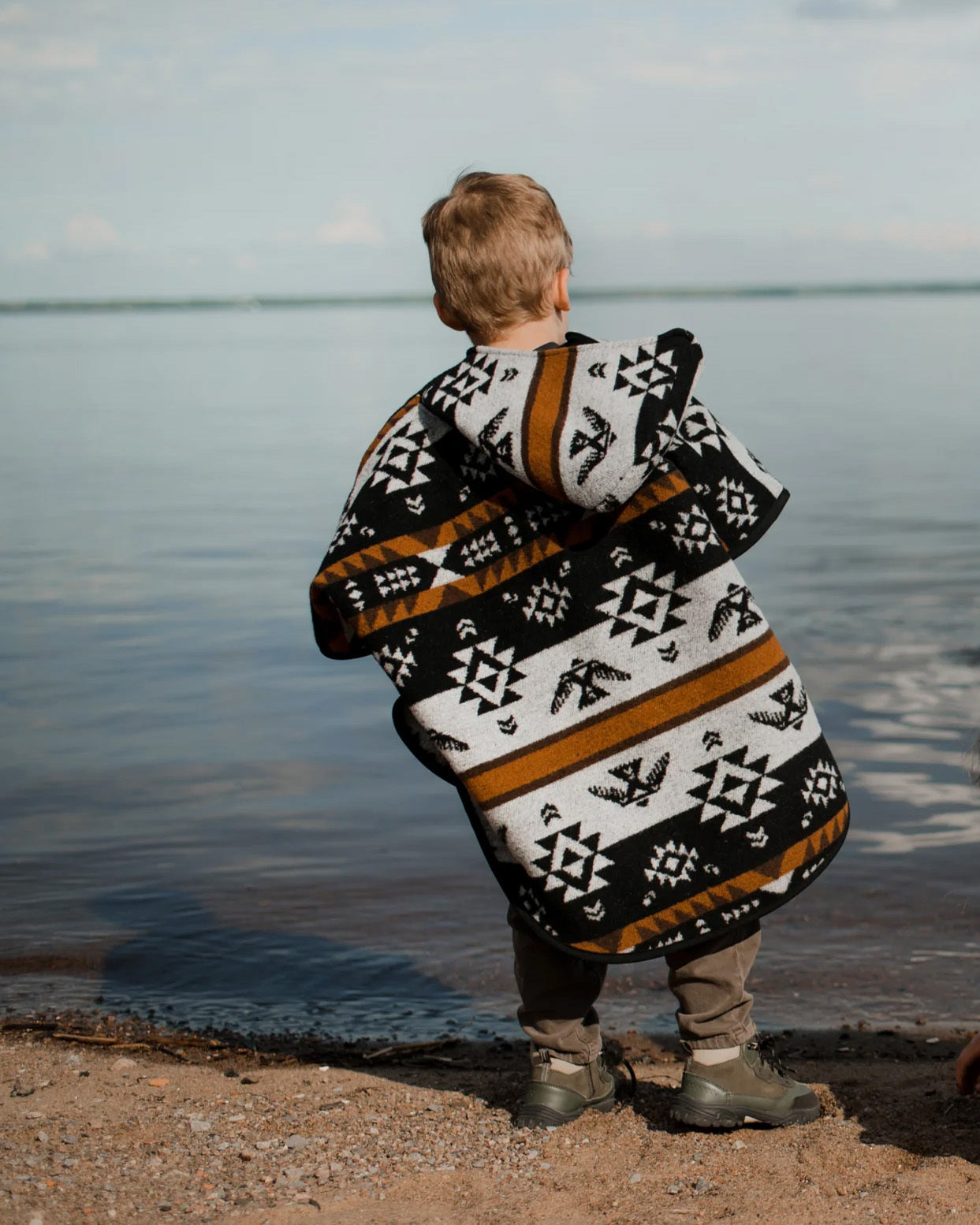 Child wearing the Mini Tipi Kids Thunderbird poncho