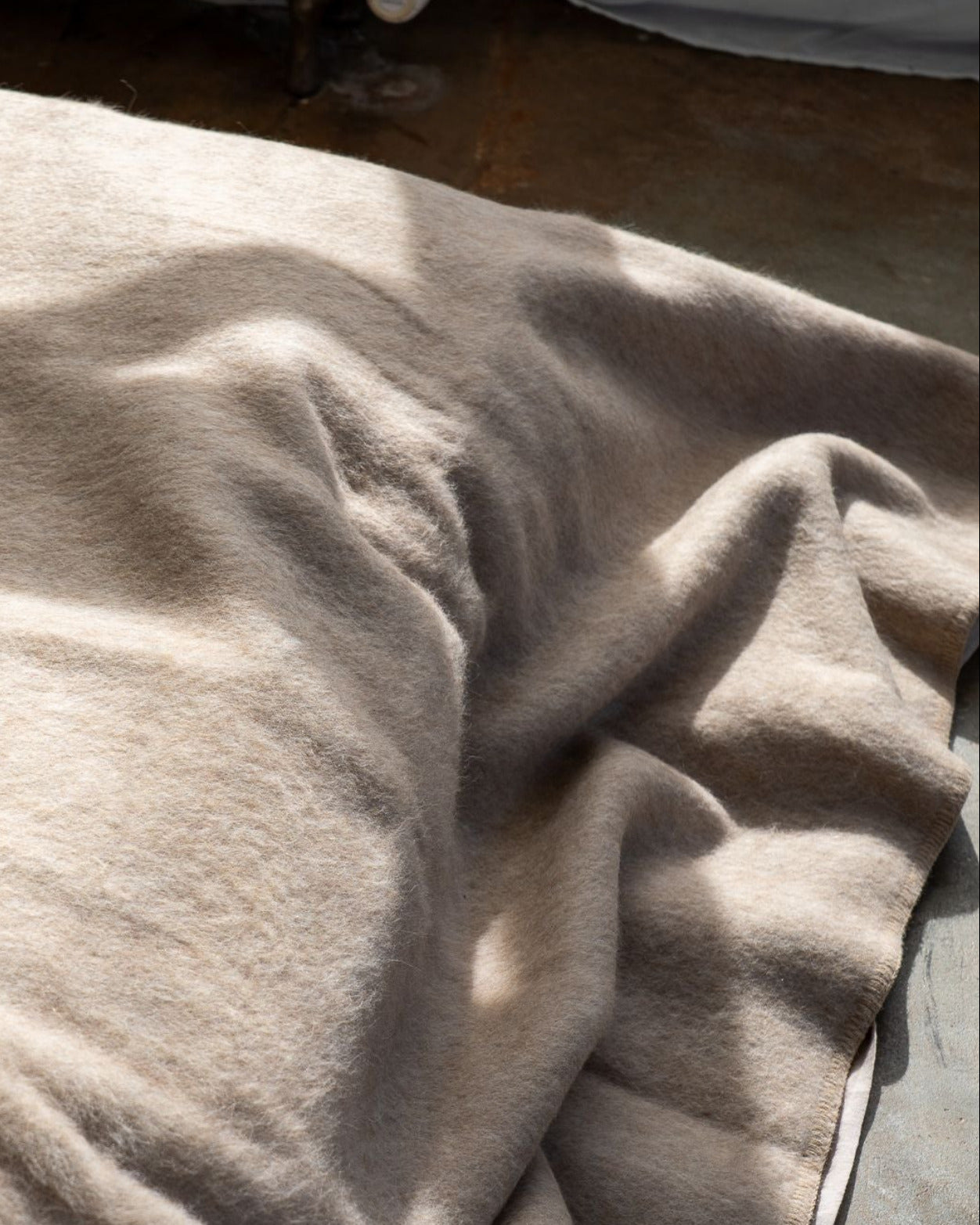 Beige blanket on a bed with a blurred background