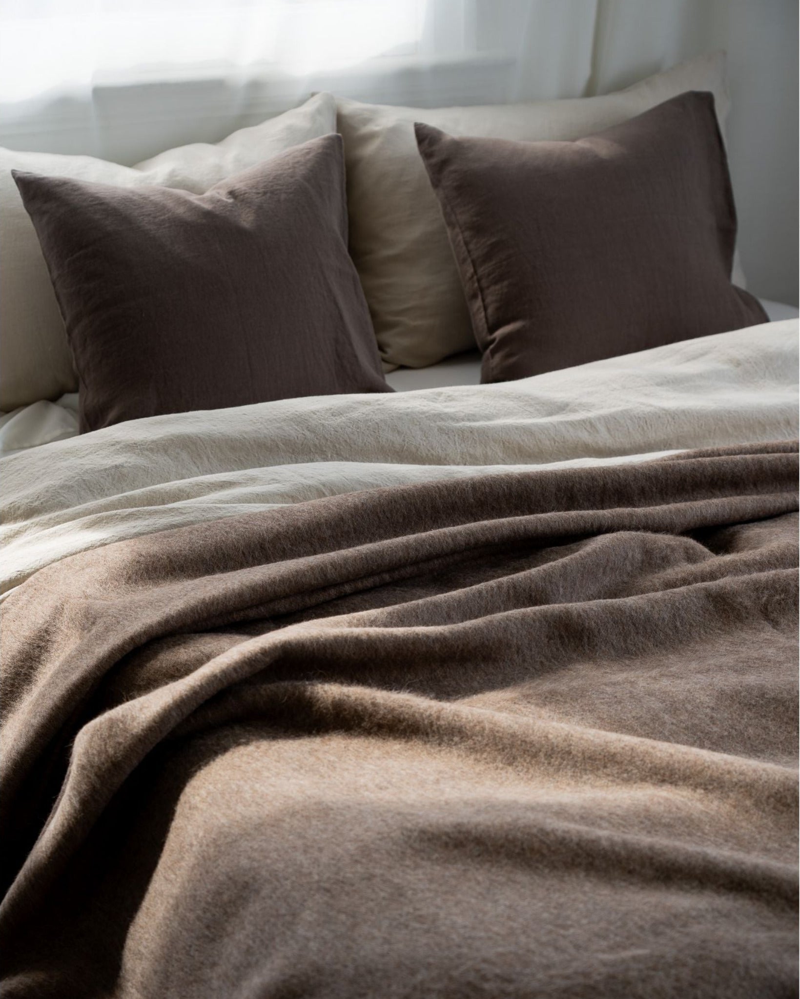Brown bedding set on a bed with pillows