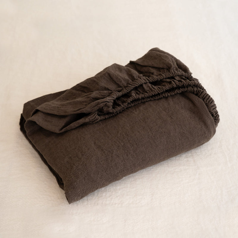 Folded brown fabric on a textured beige surface